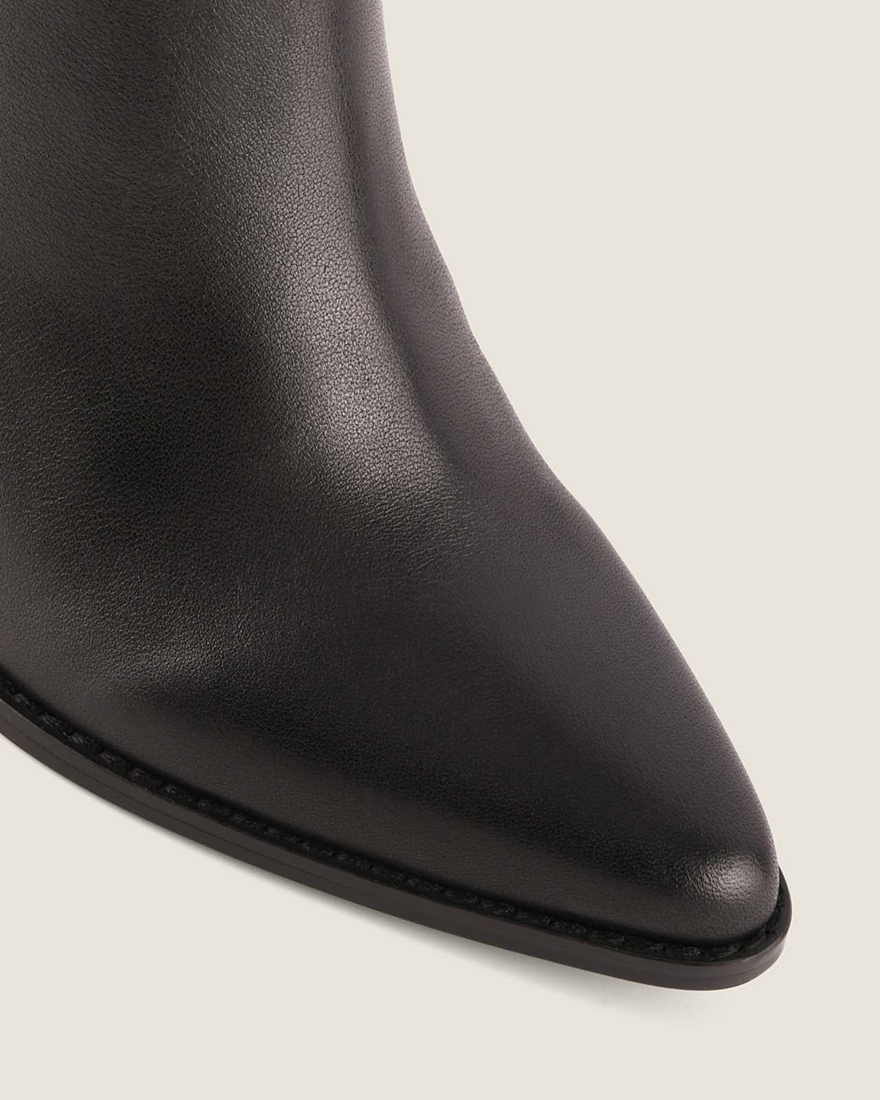 Close-up of a black leather boot on a light grey background