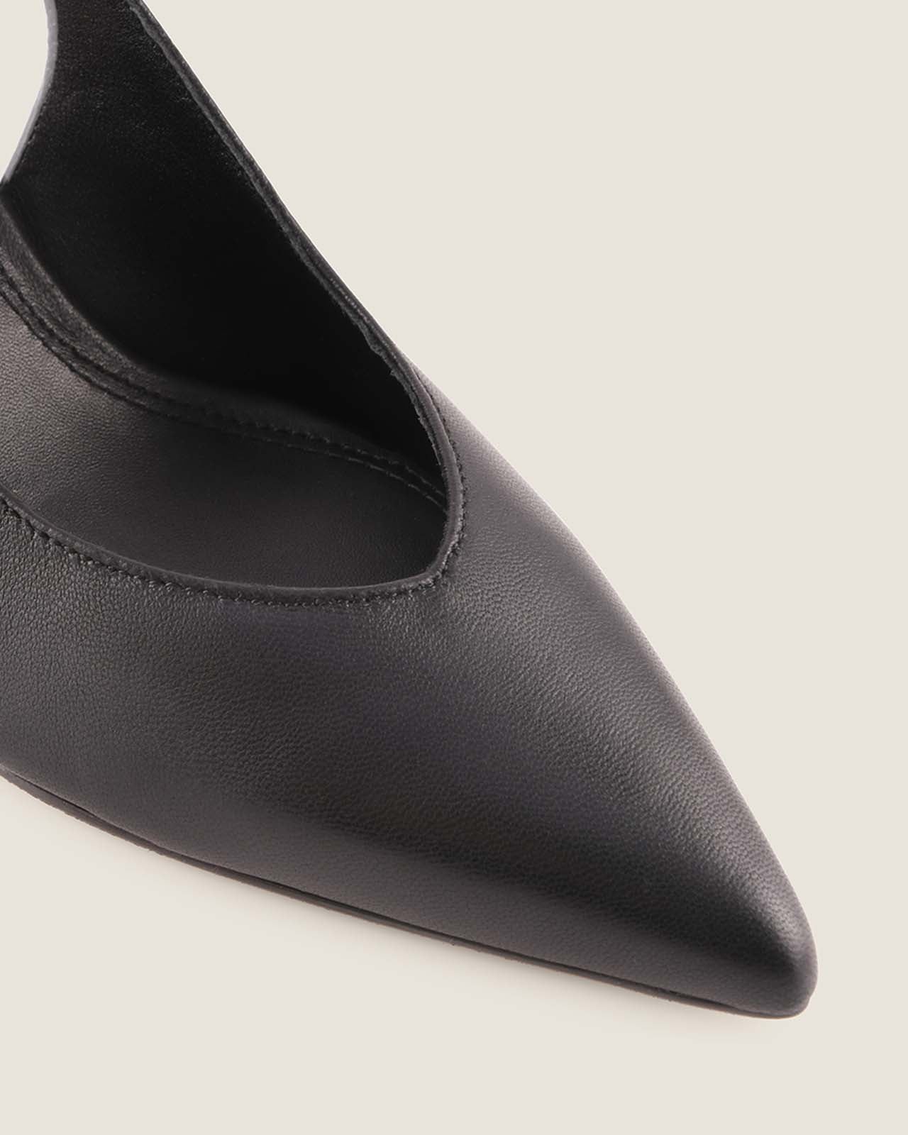 Black leather pointed-toe shoe on a light grey background