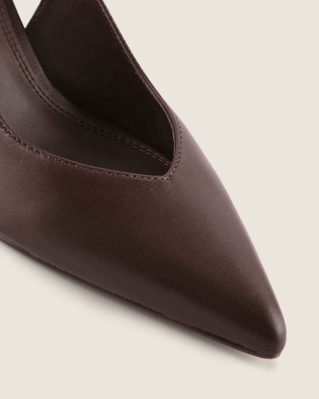 Brown pointed-toe leather shoe on a light background