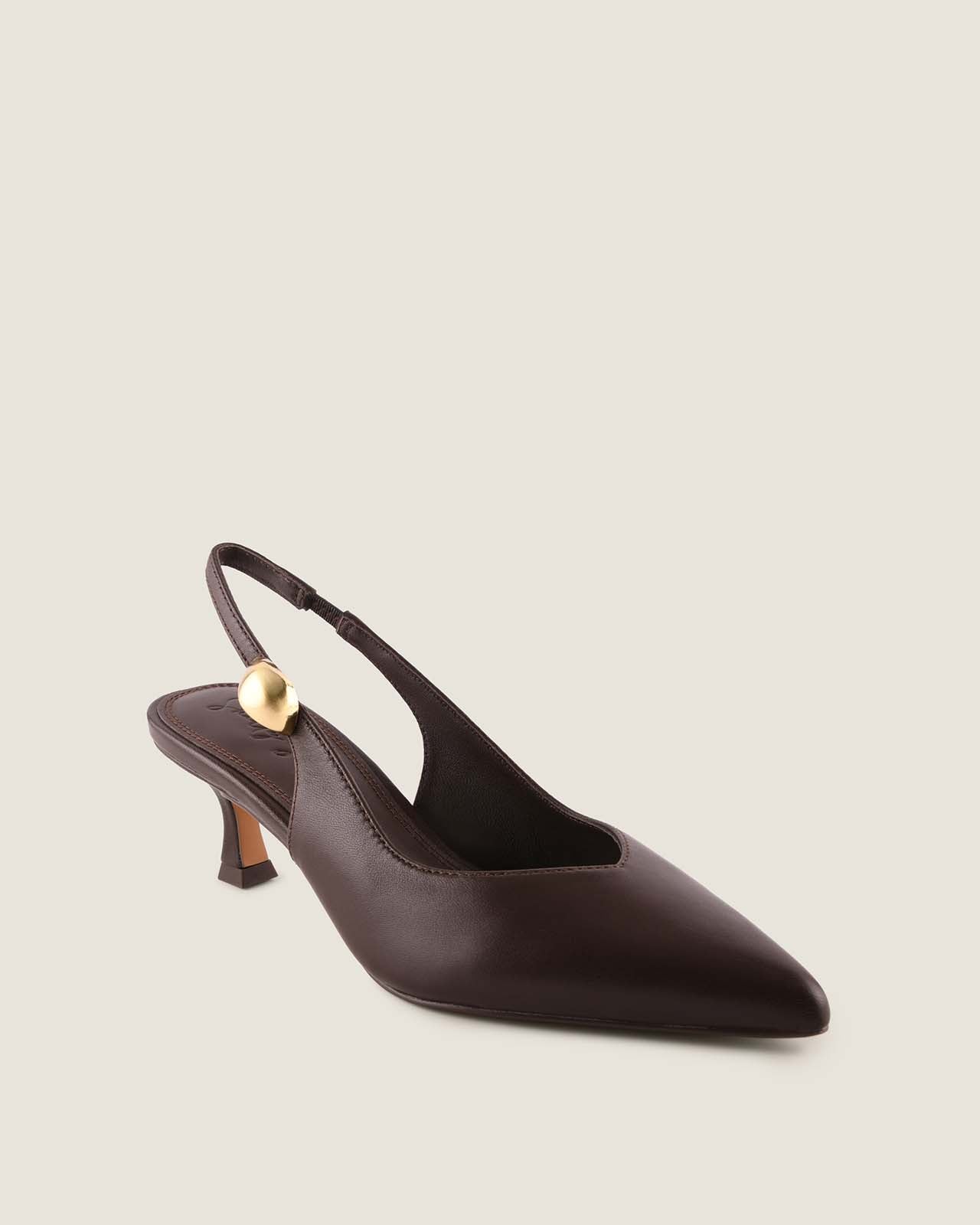 Brown leather slingback heel with a gold ornament detail on a light beige background