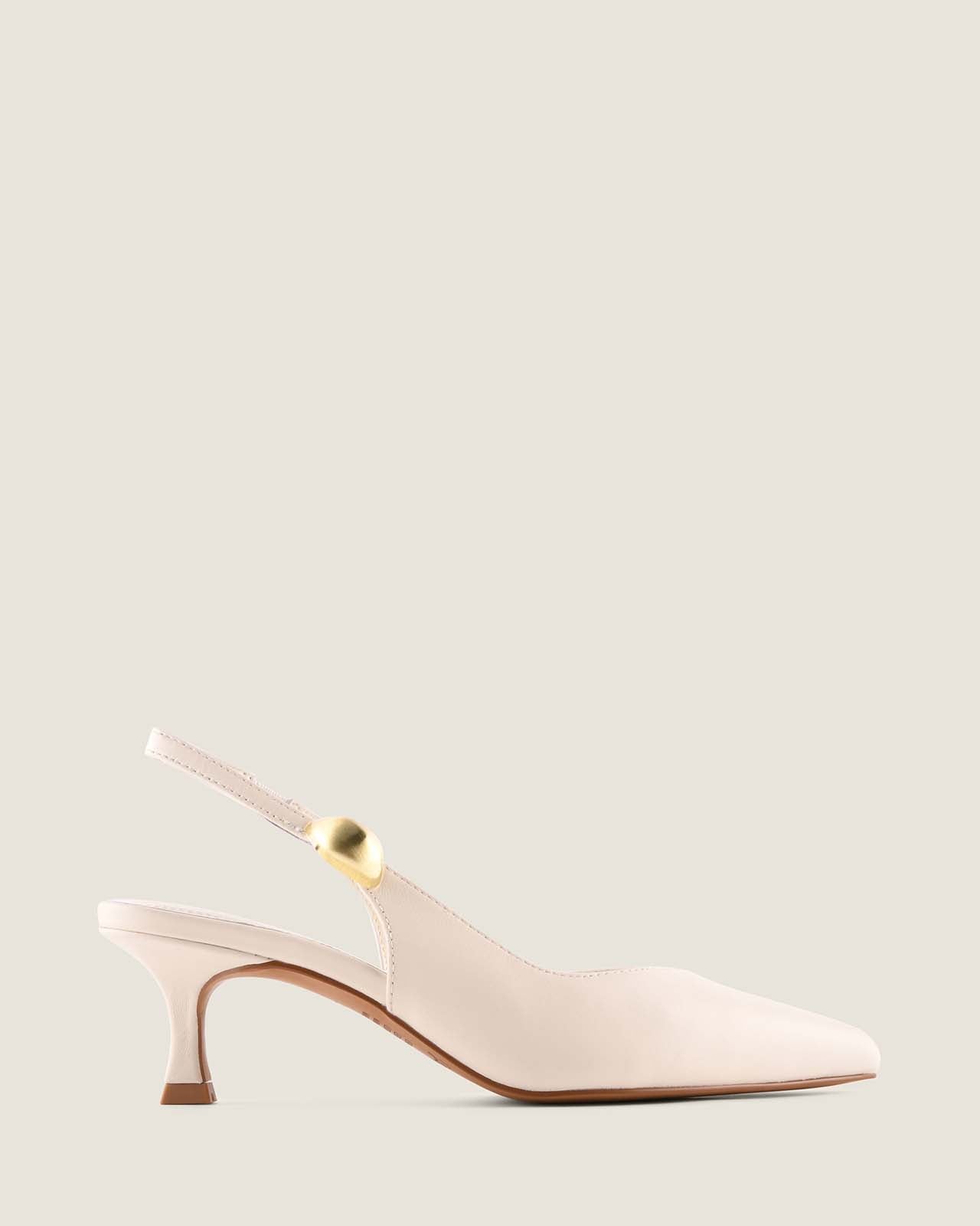 White leather slingback heel with a gold ornament detail on a light beige background