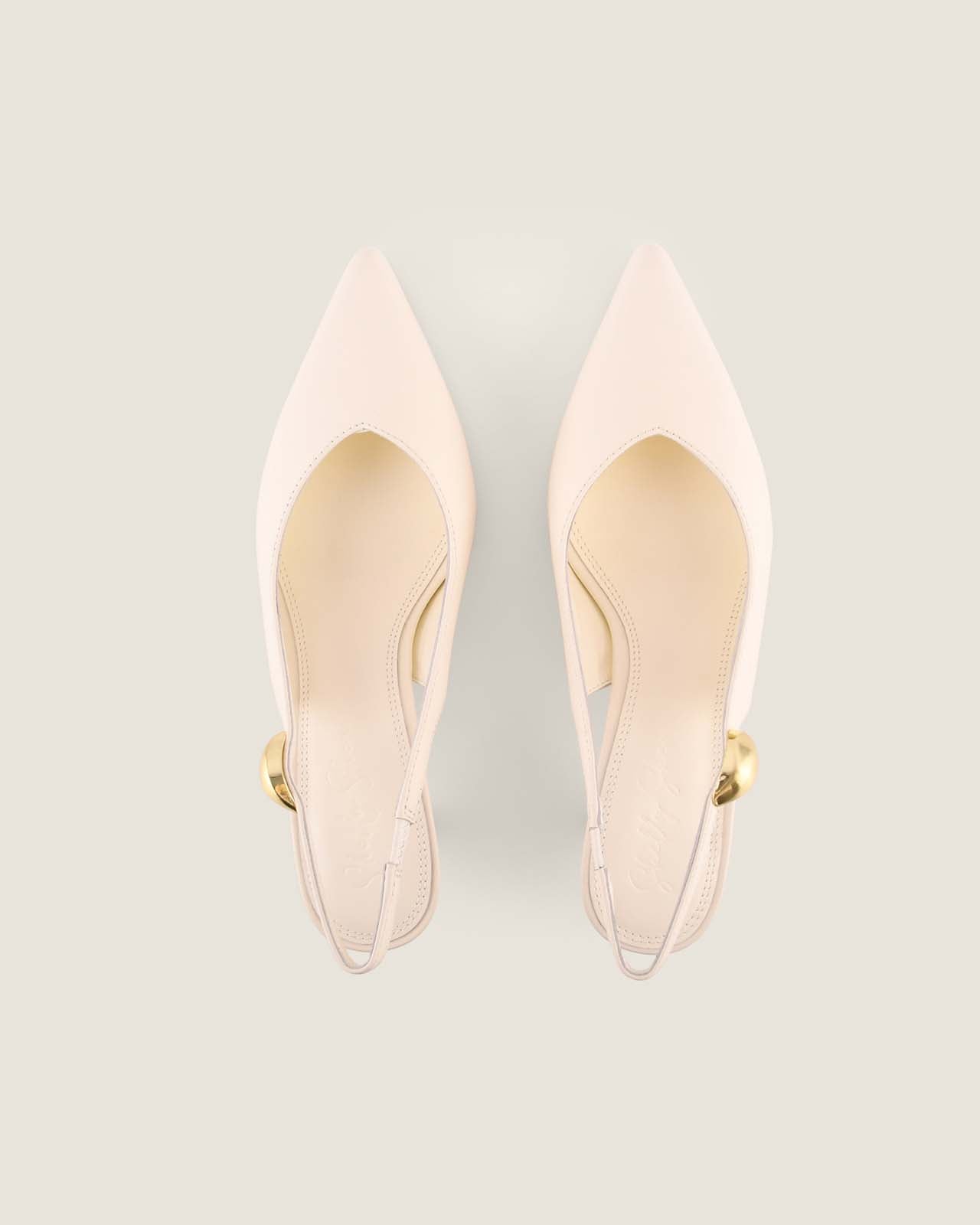 Pair of white high-heeled shoes on a light grey background