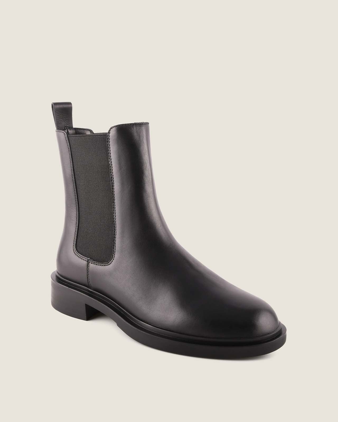 Black leather boot on a light grey background