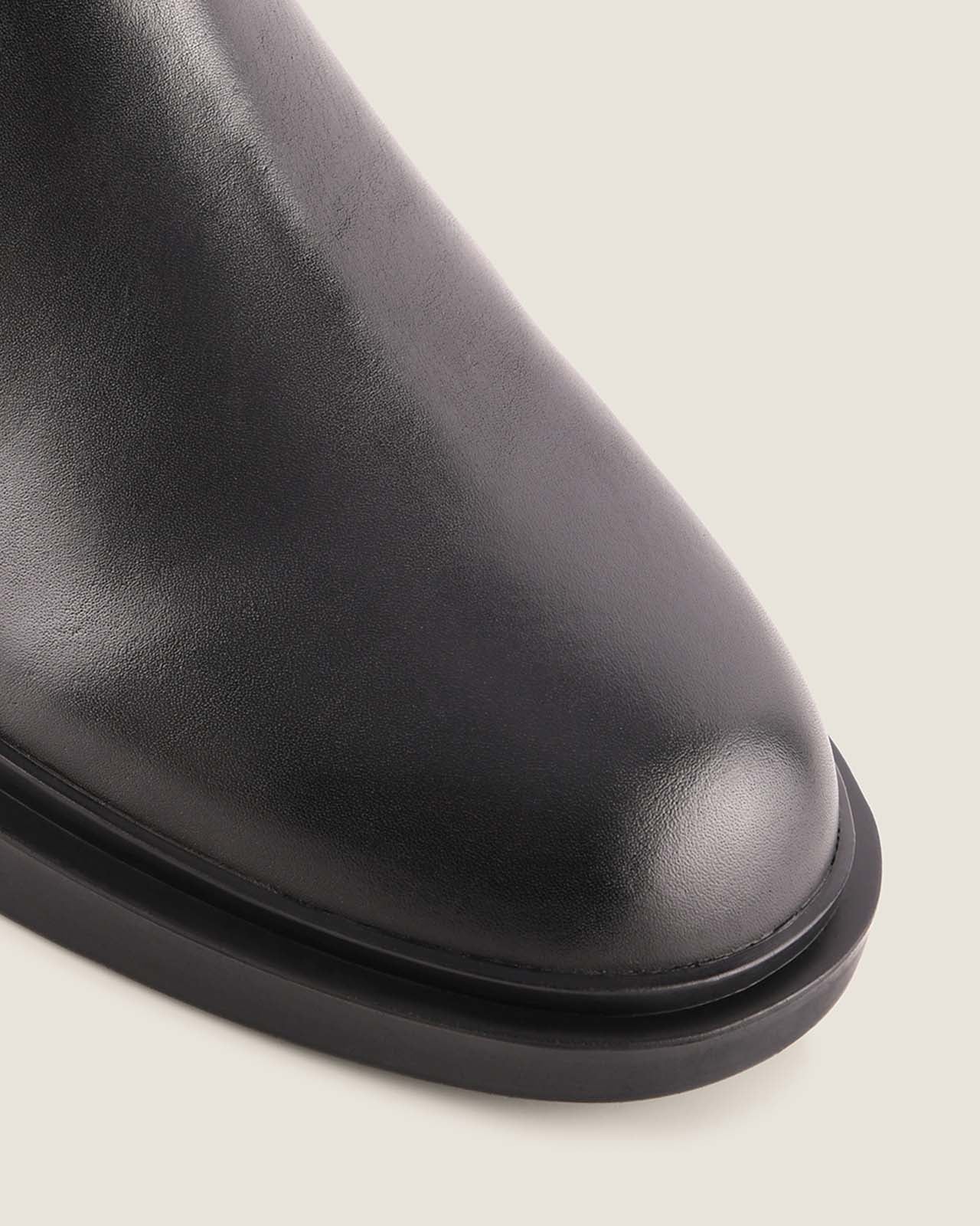 Close-up of a black leather shoe on a light background