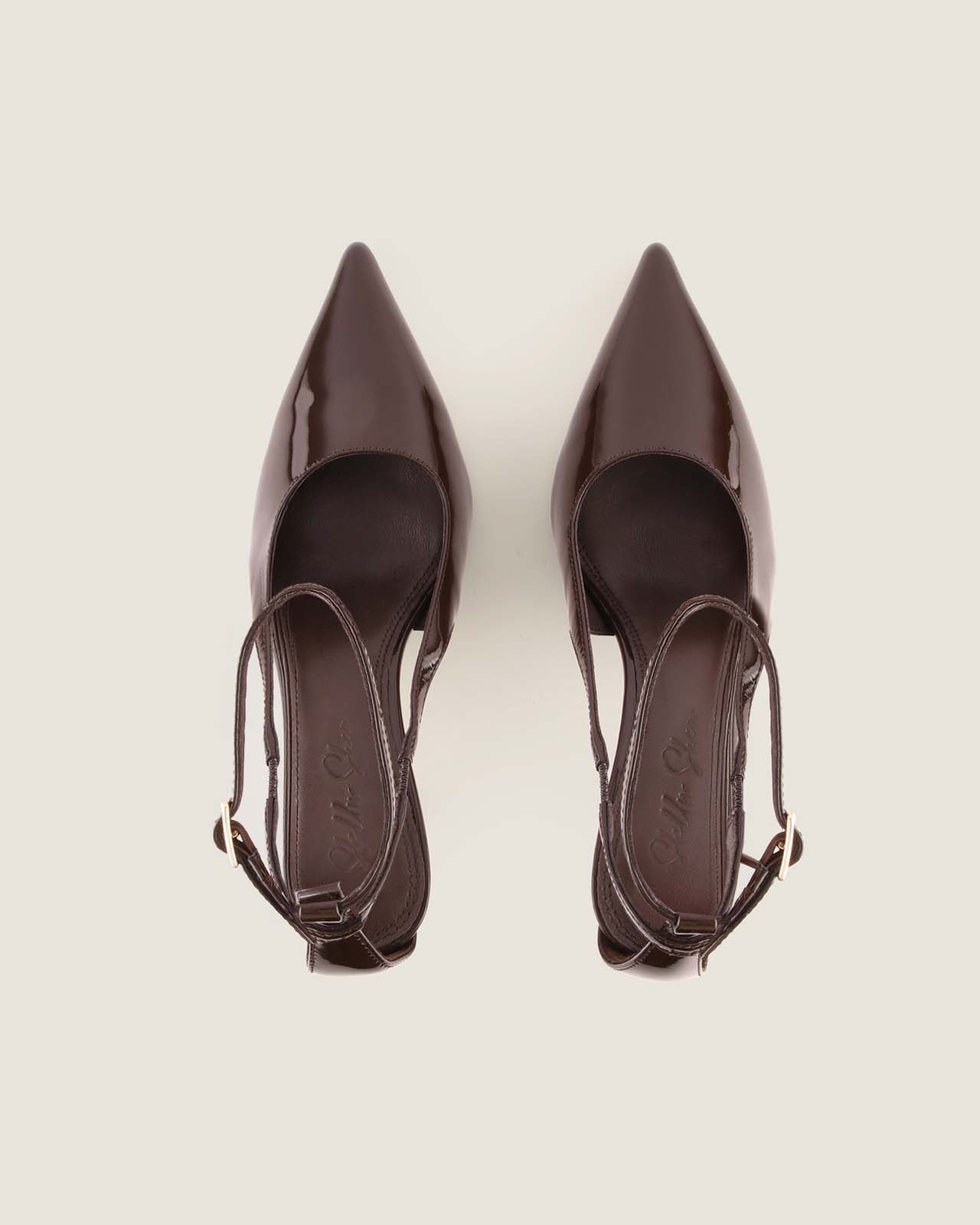Pair of brown high-heeled shoes on a light grey background
