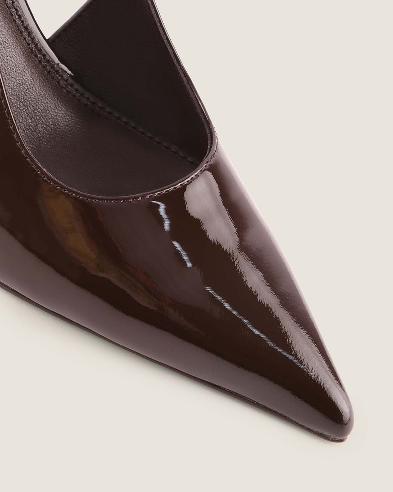 Close-up of a brown pointed-toe shoe on a light background