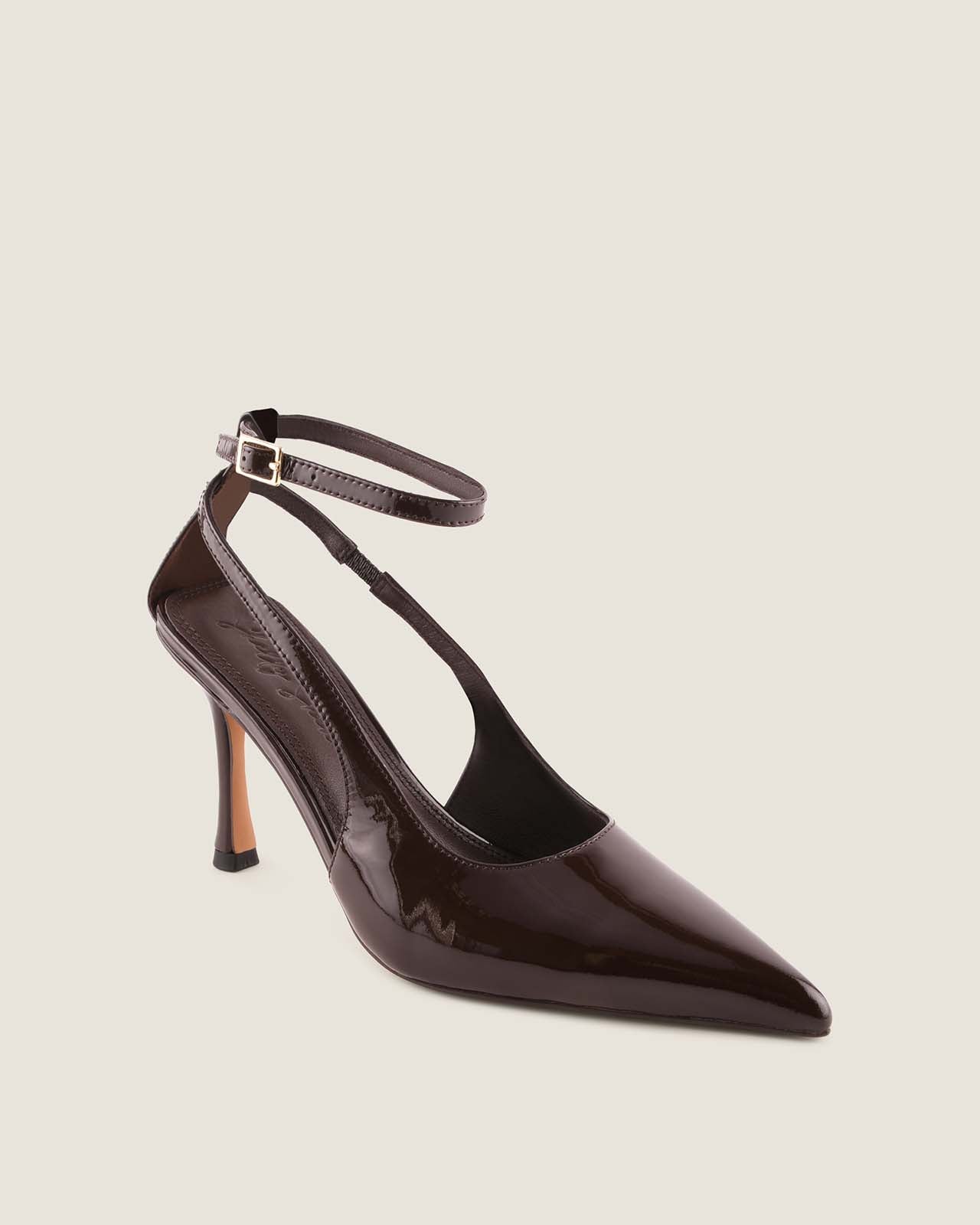 Brown patent leather high-heeled shoe with ankle strap on a beige background