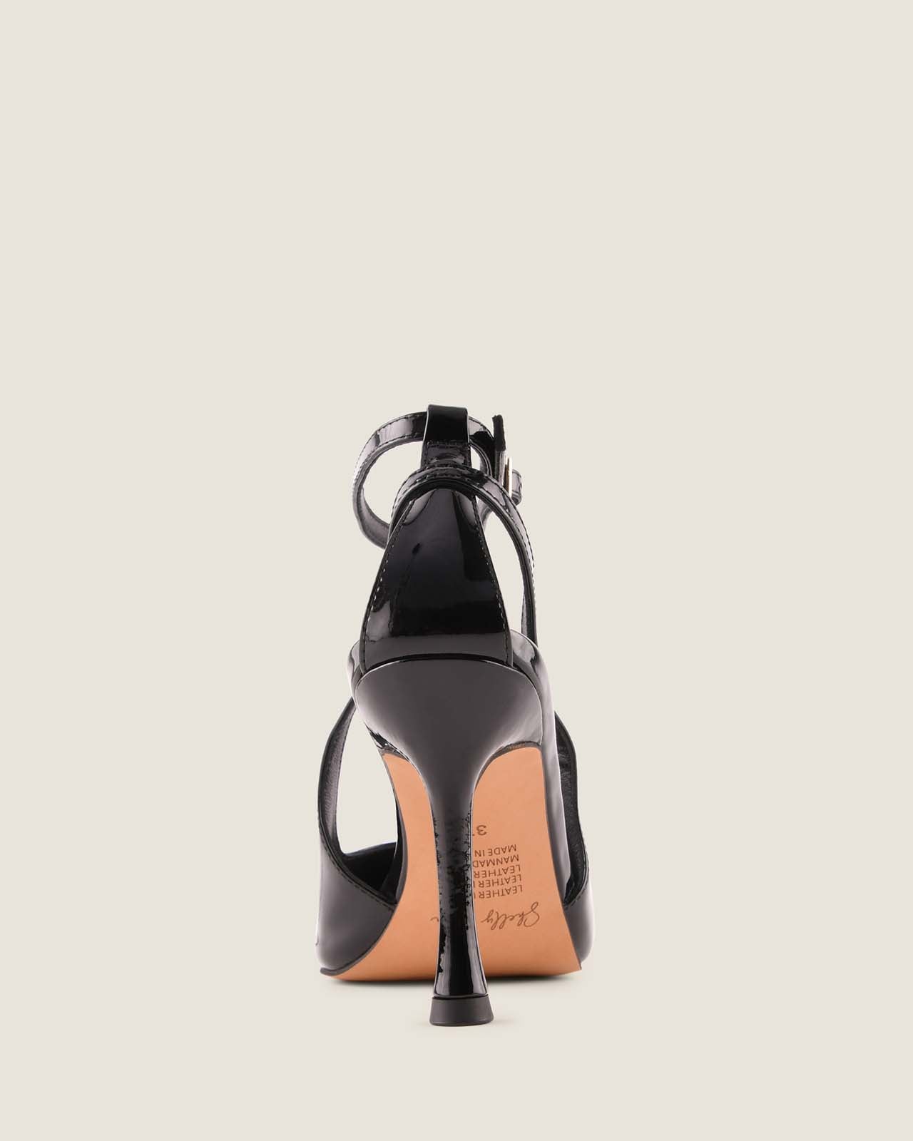 Black high-heeled shoe on a light grey background