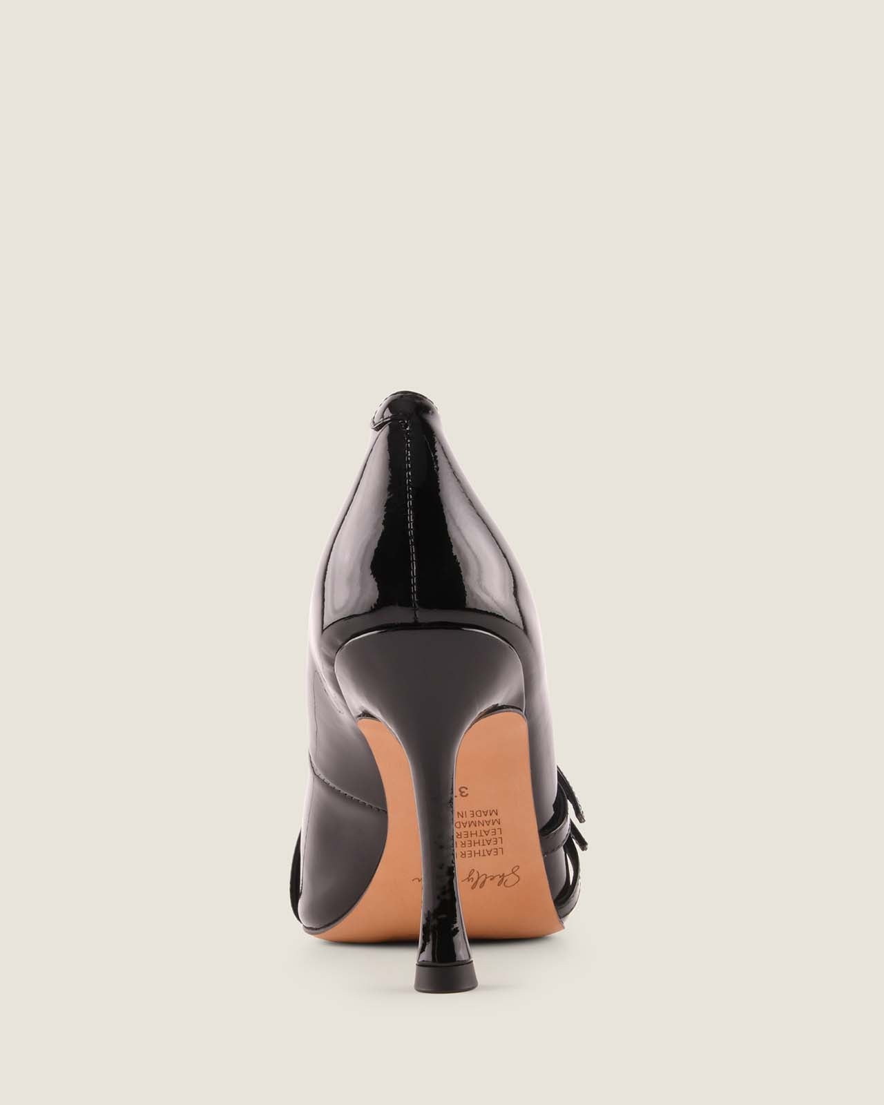 Black high-heeled shoe on a light beige background