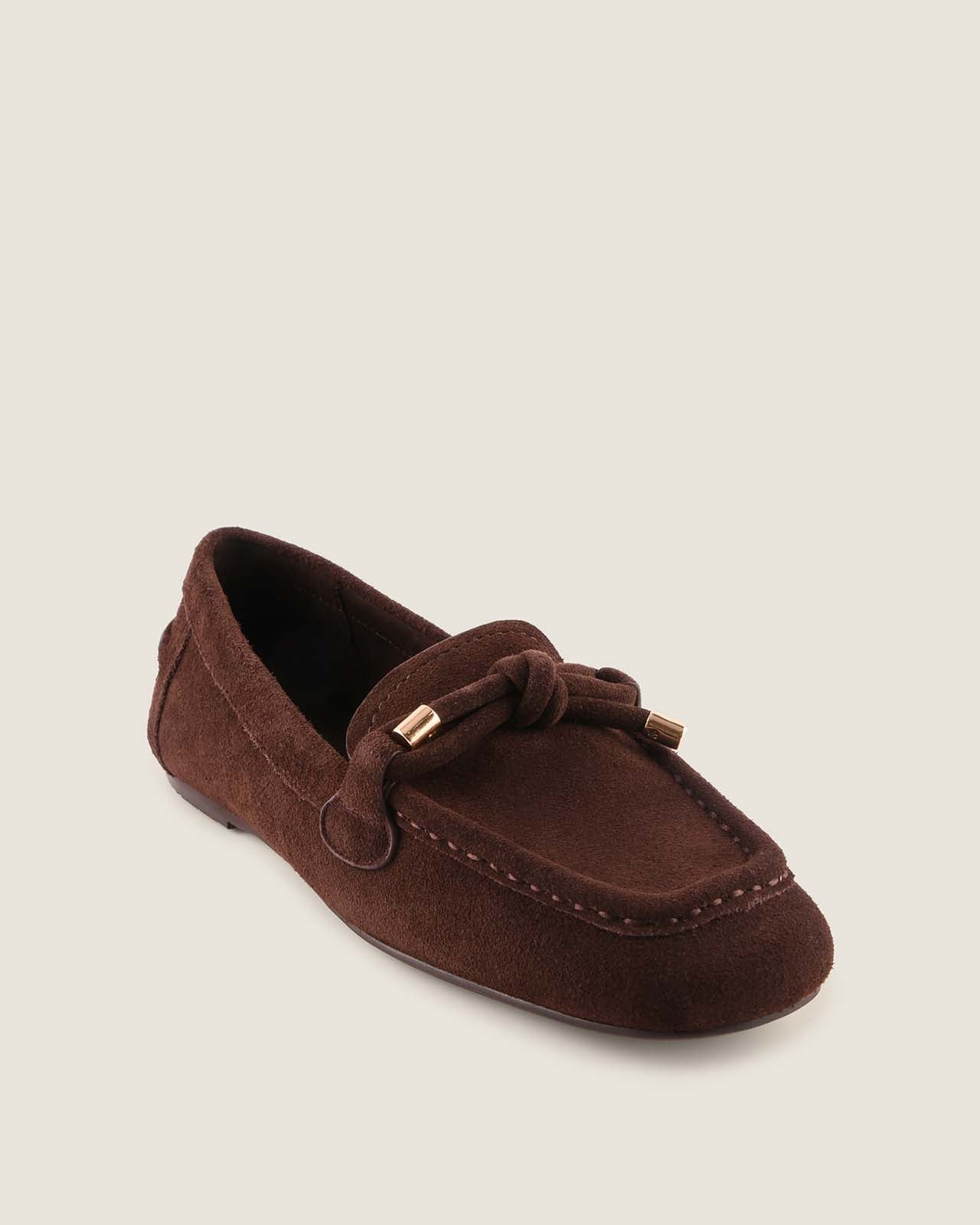 Brown suede loafer shoe on a light beige background