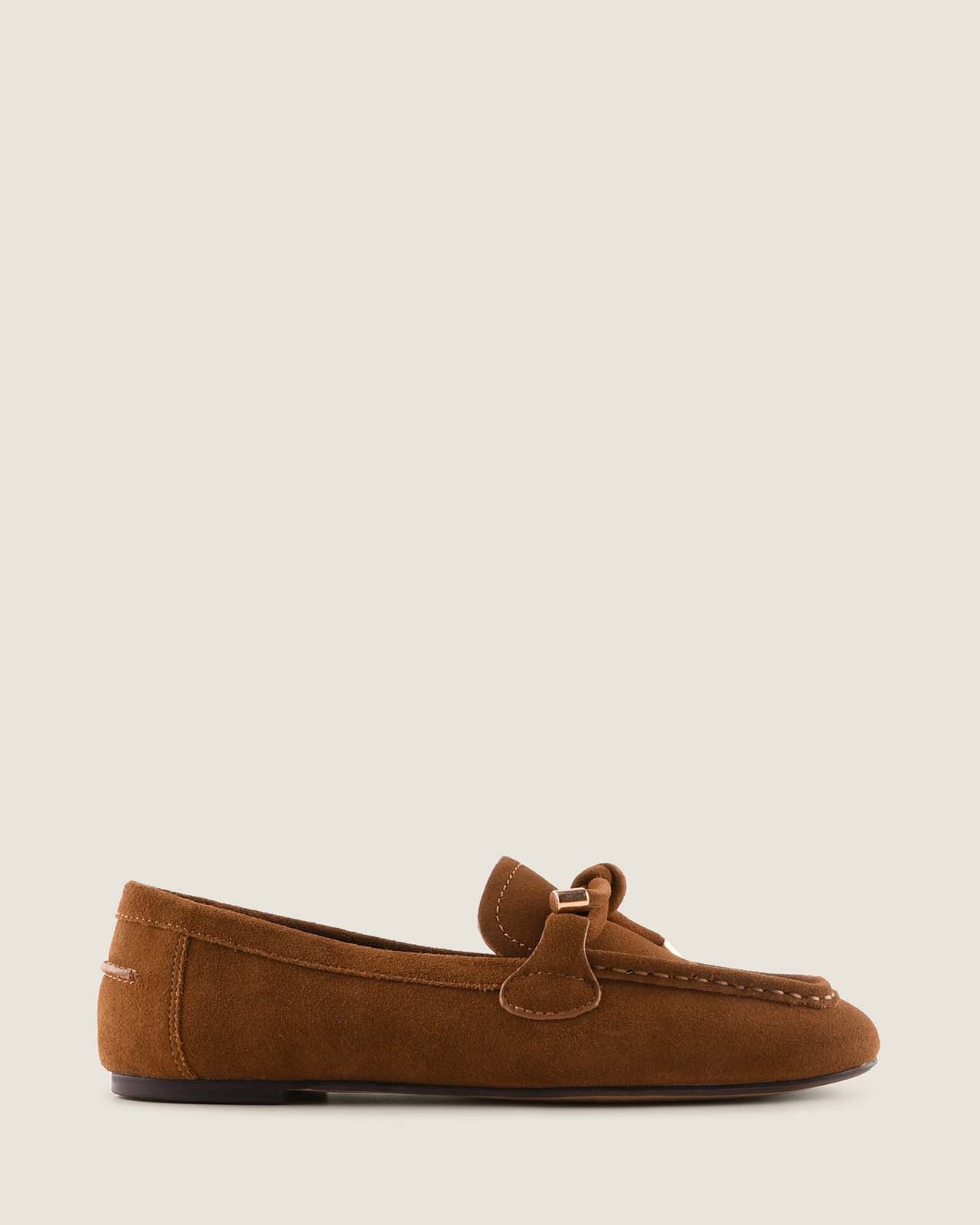 Tan suede loafer shoe on a beige background