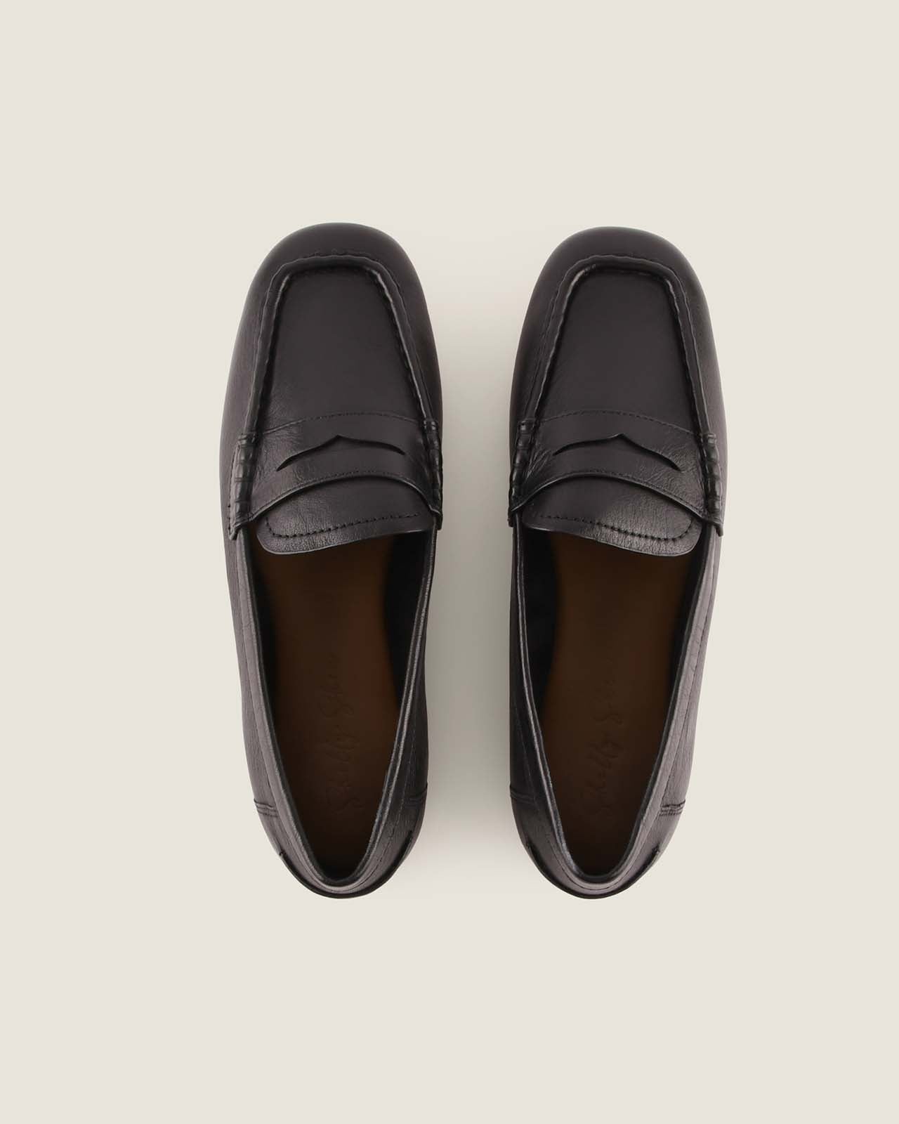 Pair of black loafers on a light grey background