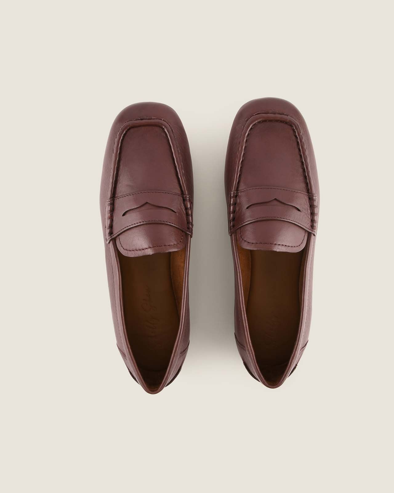 Pair of brown leather loafers on a light grey background