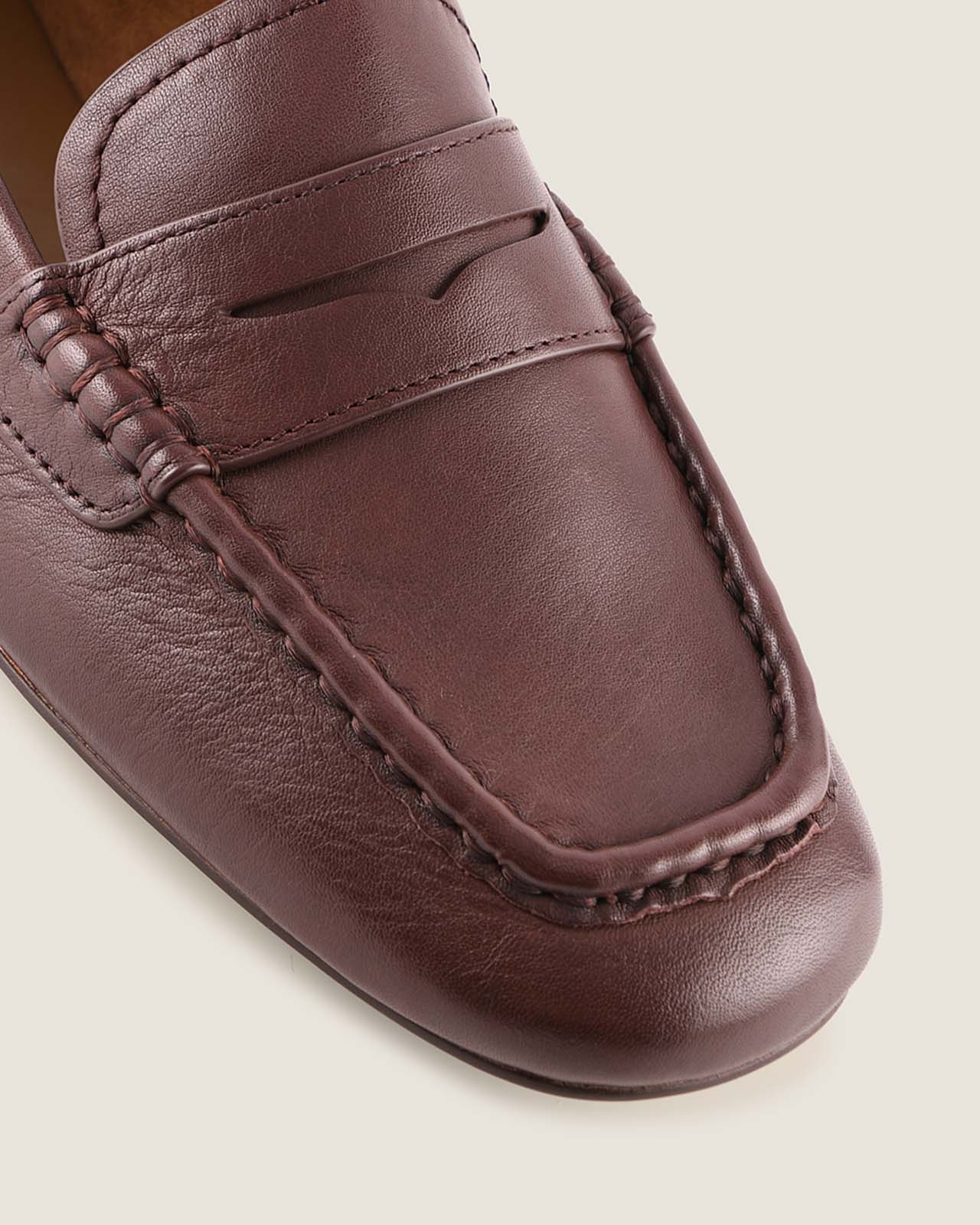 Close-up of a brown leather loafer shoe on a light background