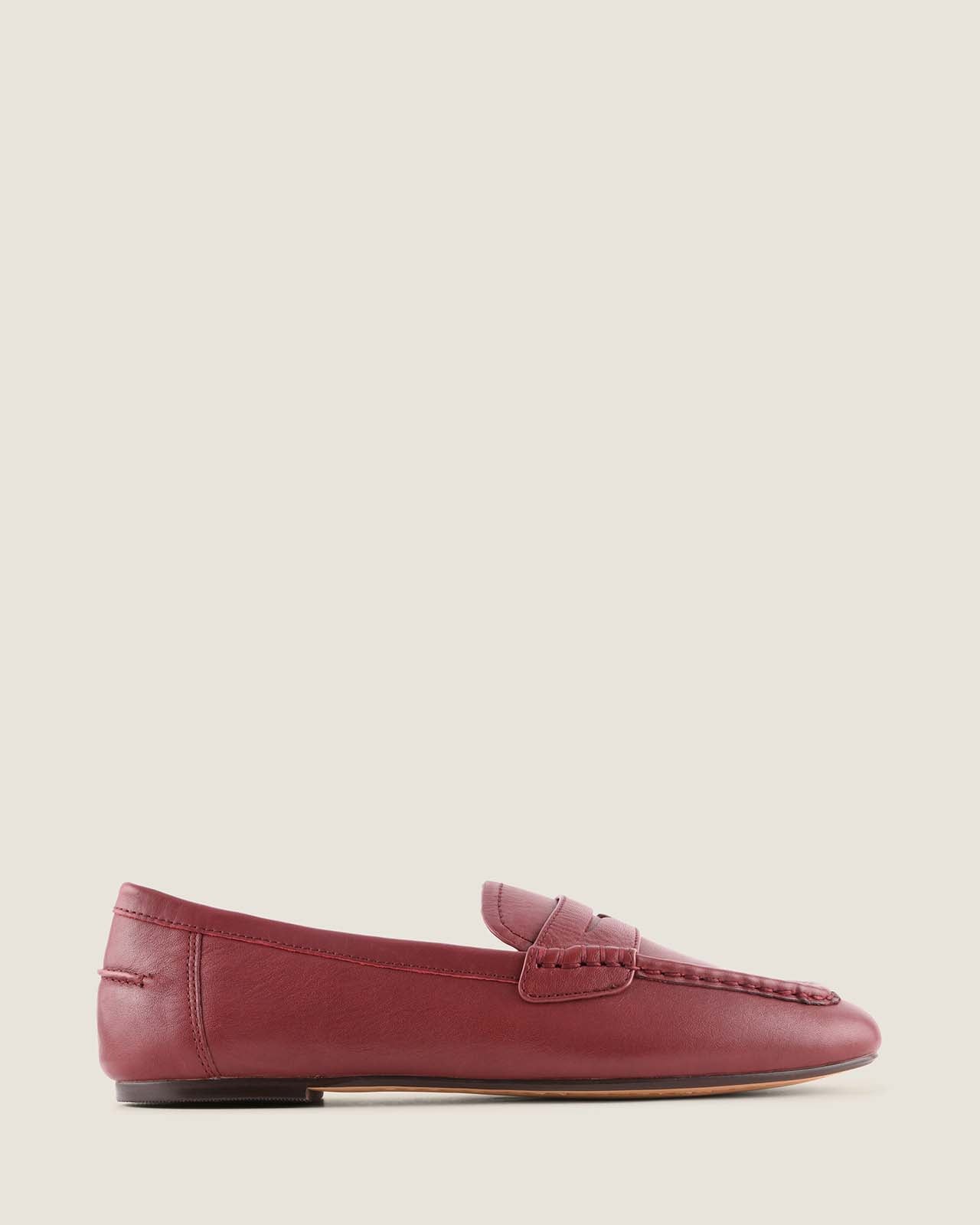 Burgundy leather loafer shoe on a beige background