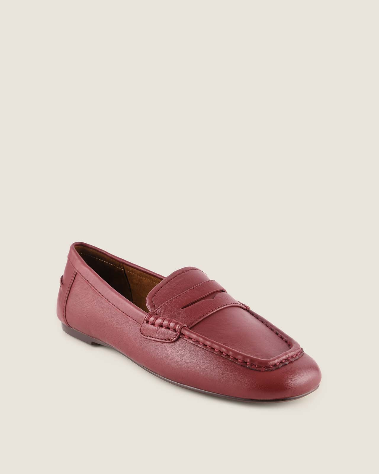 Burgundy loafer shoe on a beige background