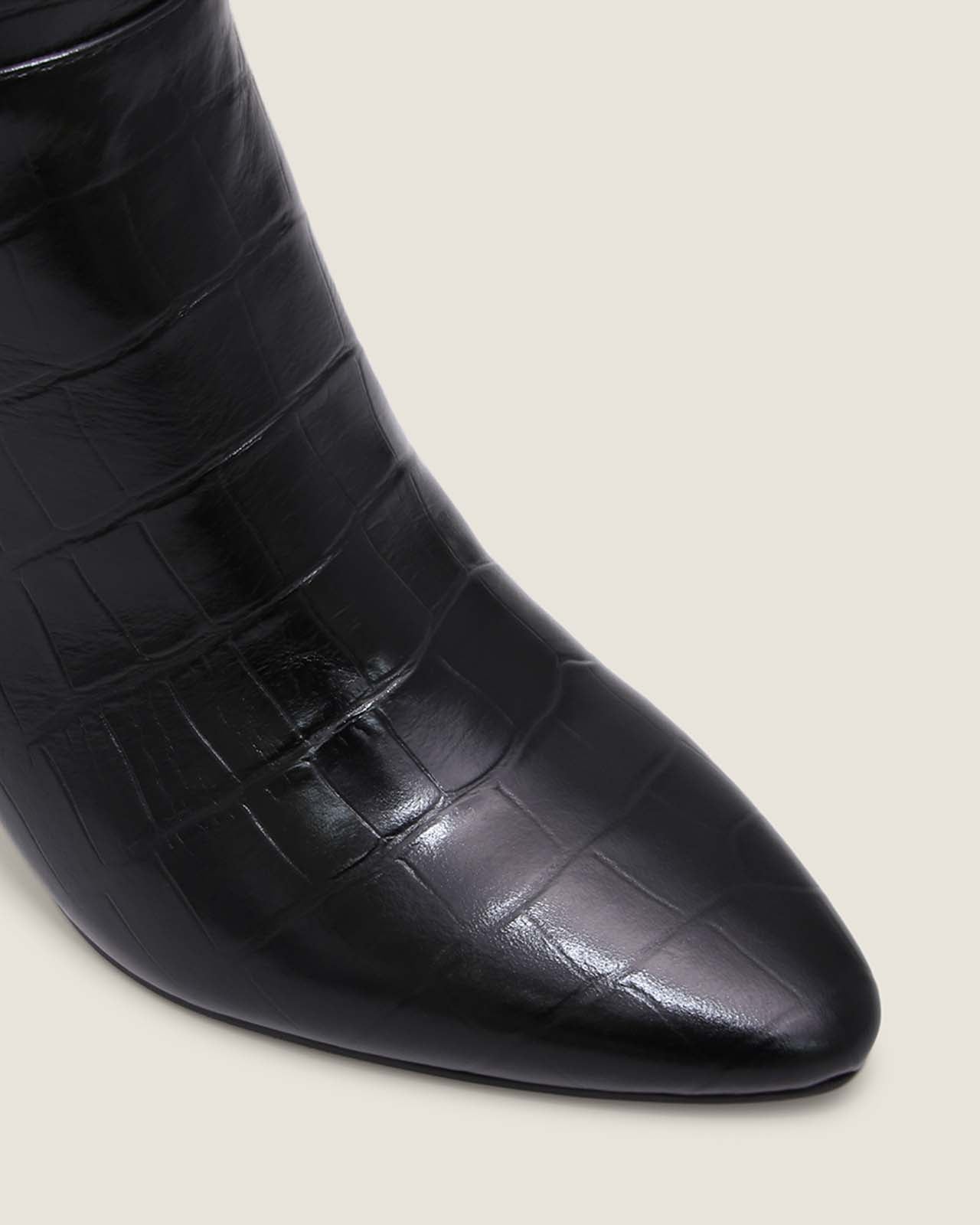 Black crocodile-patterned boot on a light grey background