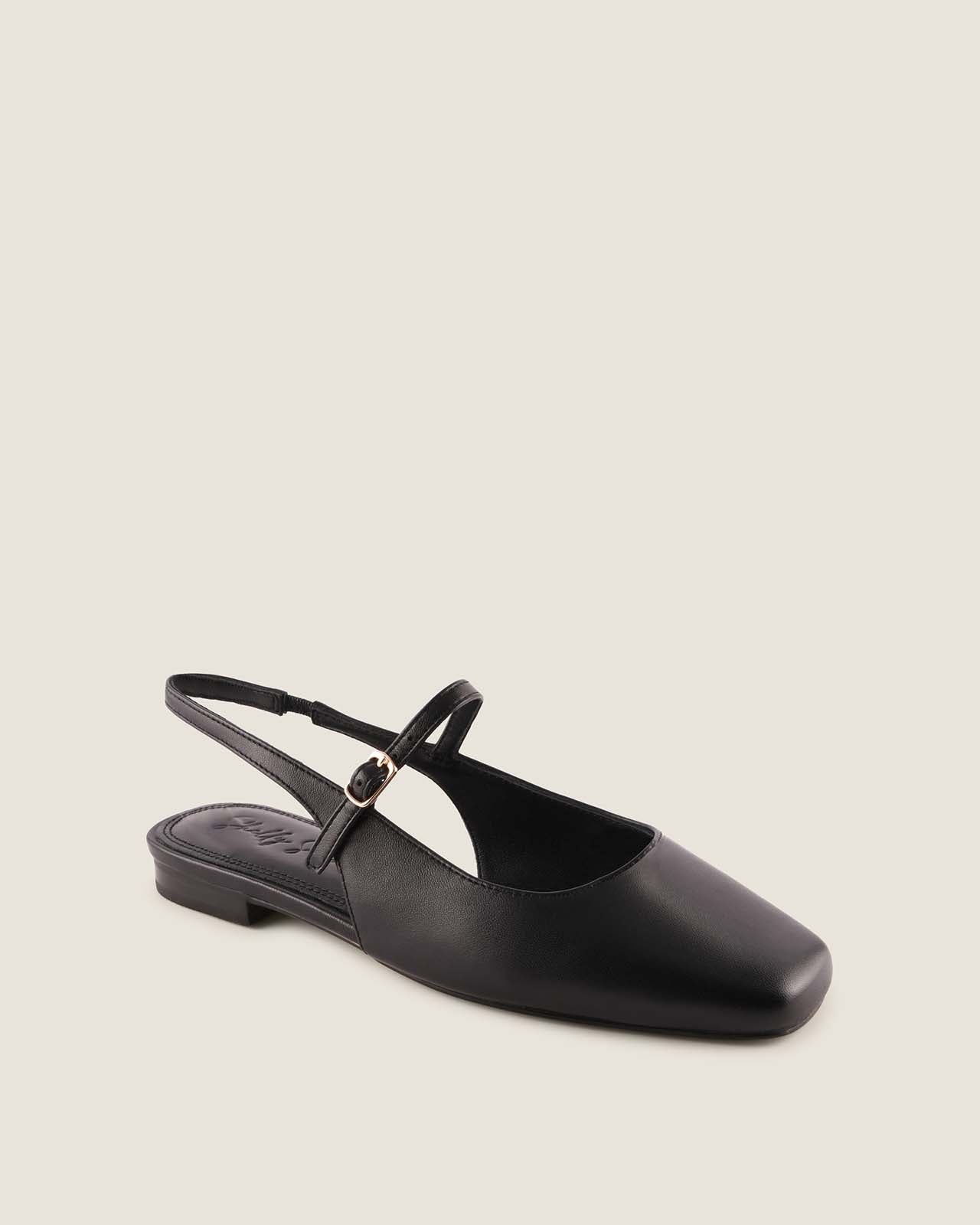 Black leather flat shoe with a slingback strap on a beige background