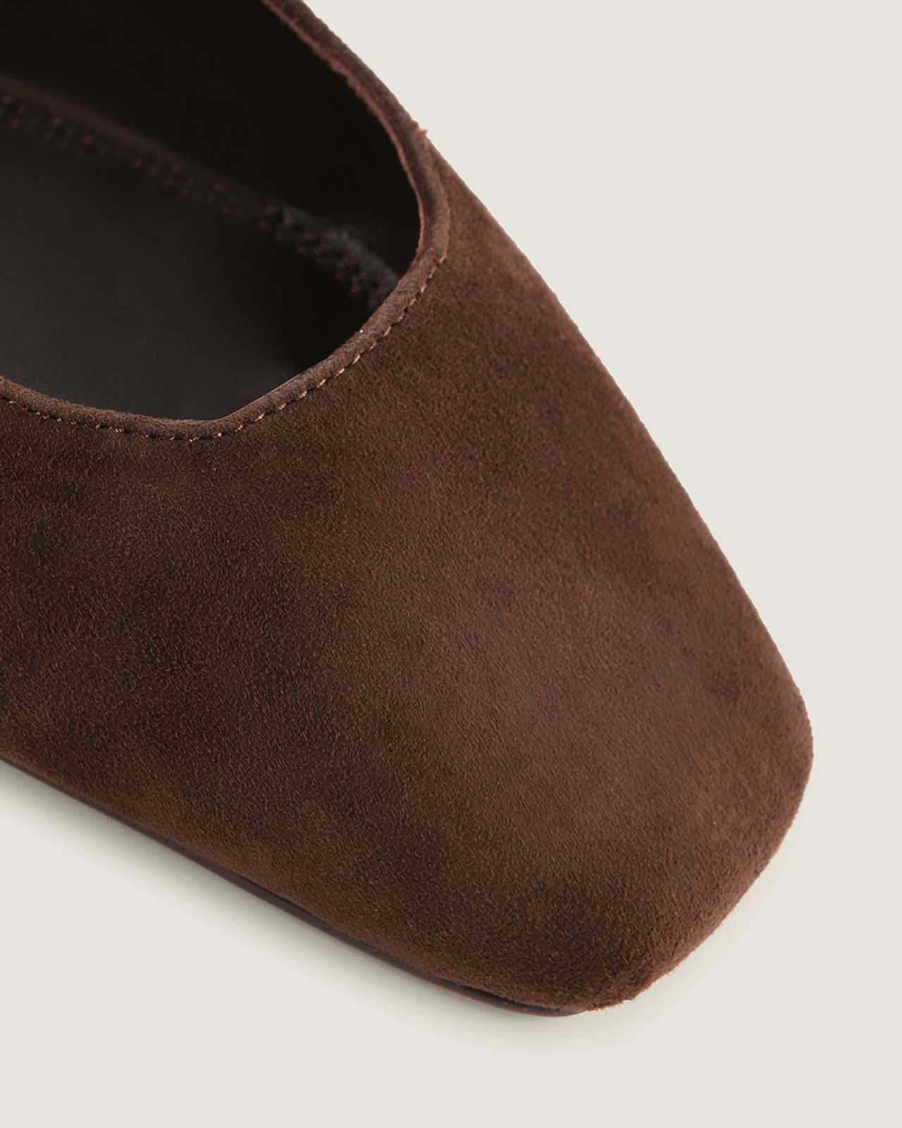 Brown suede shoe on a light grey background