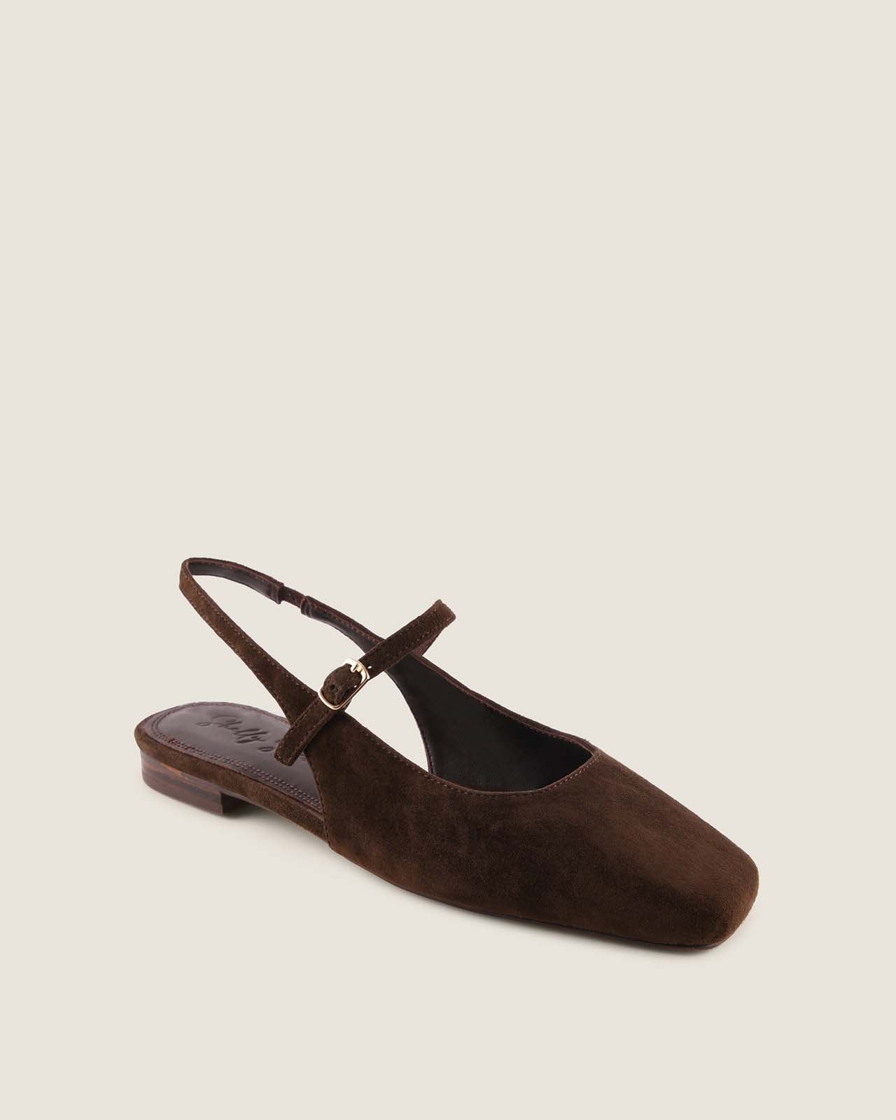 Brown suede flat with a strap on a light beige background