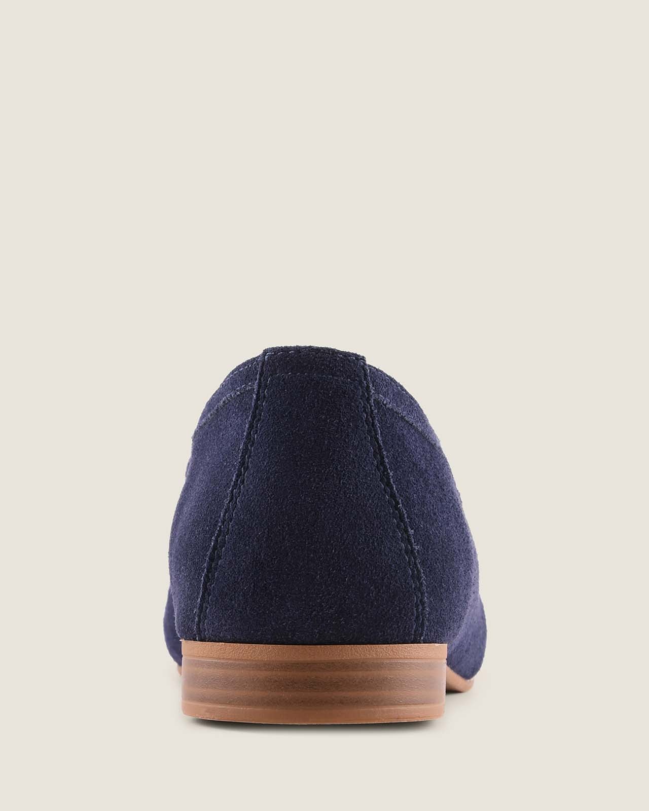 Navy blue flat shoe with a brown sole on a light gray background
