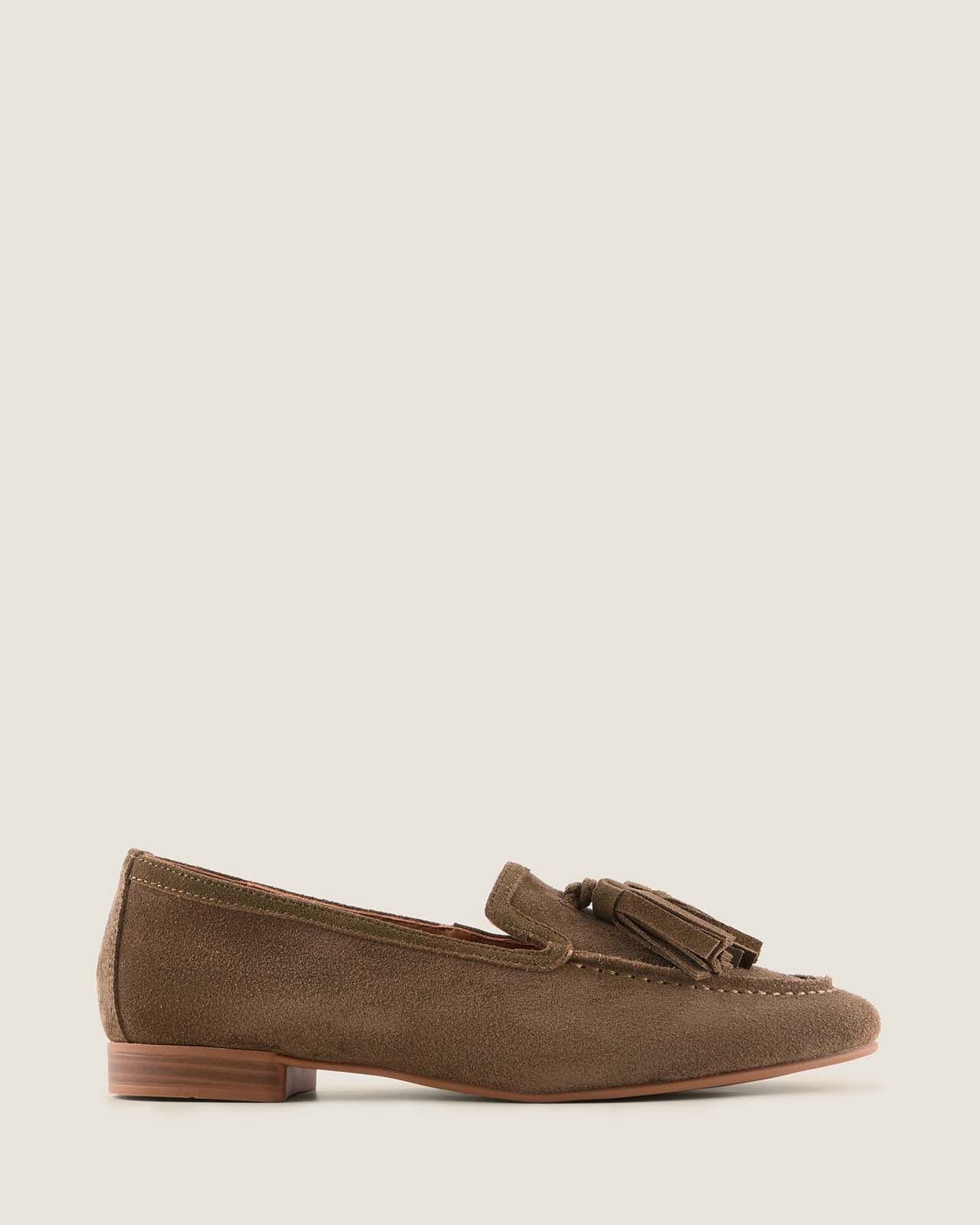 Olive suede loafer with a tassel on a light grey background