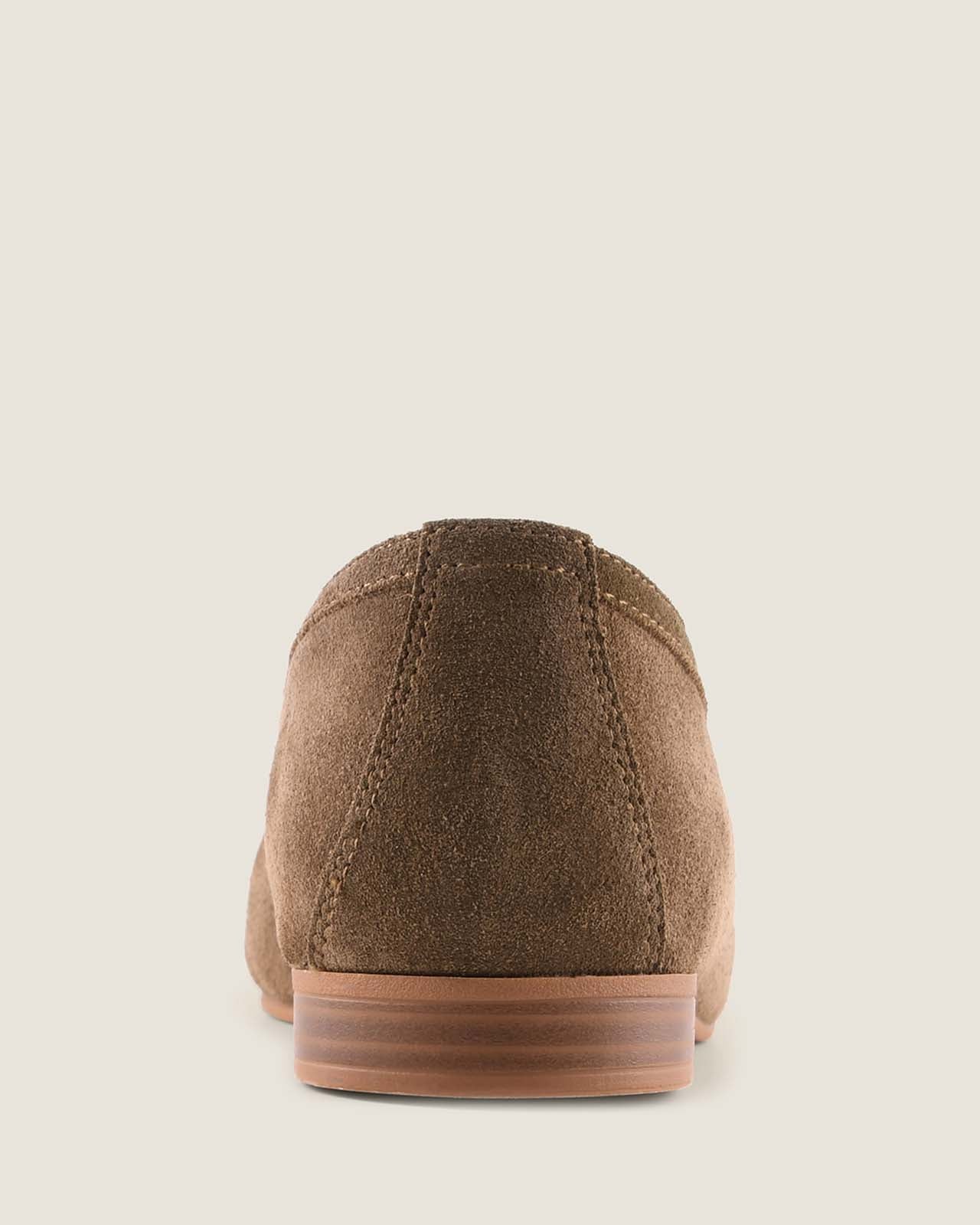 Olive suede loafer with a tassel on a light grey background