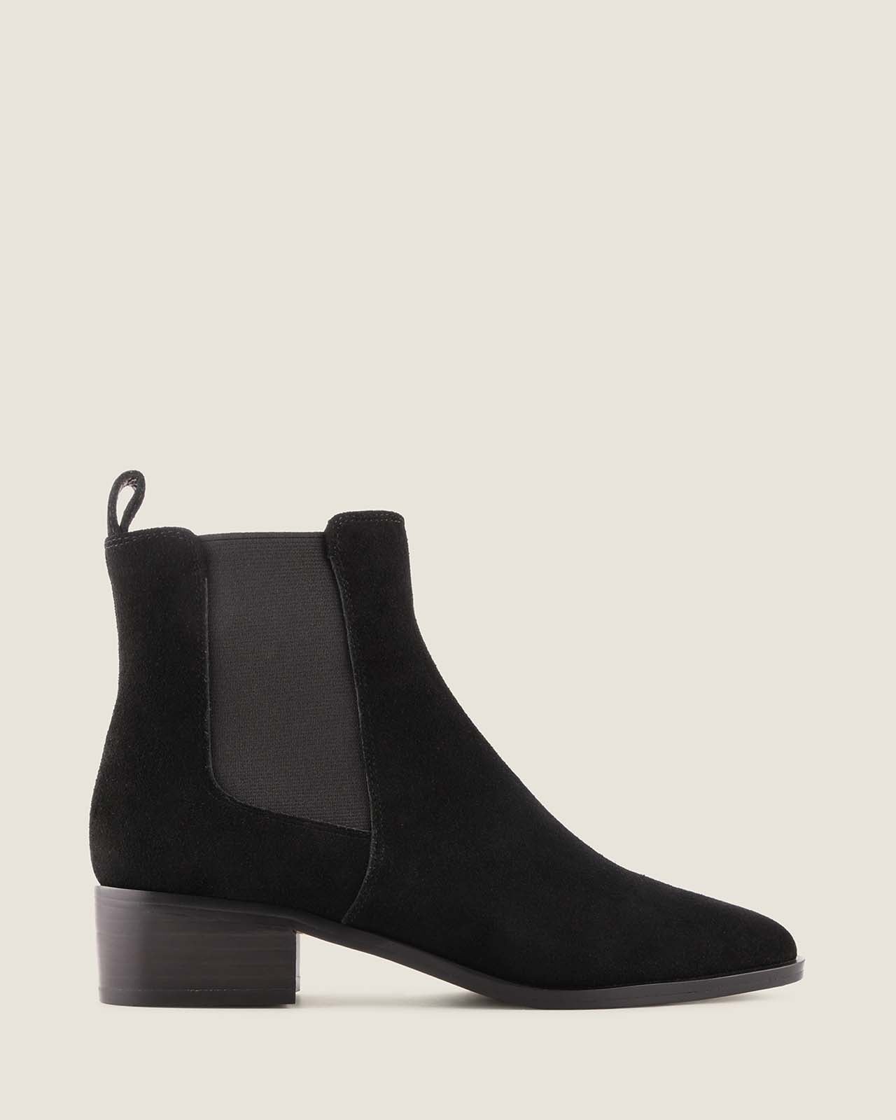 Black suede boot on a light grey background
