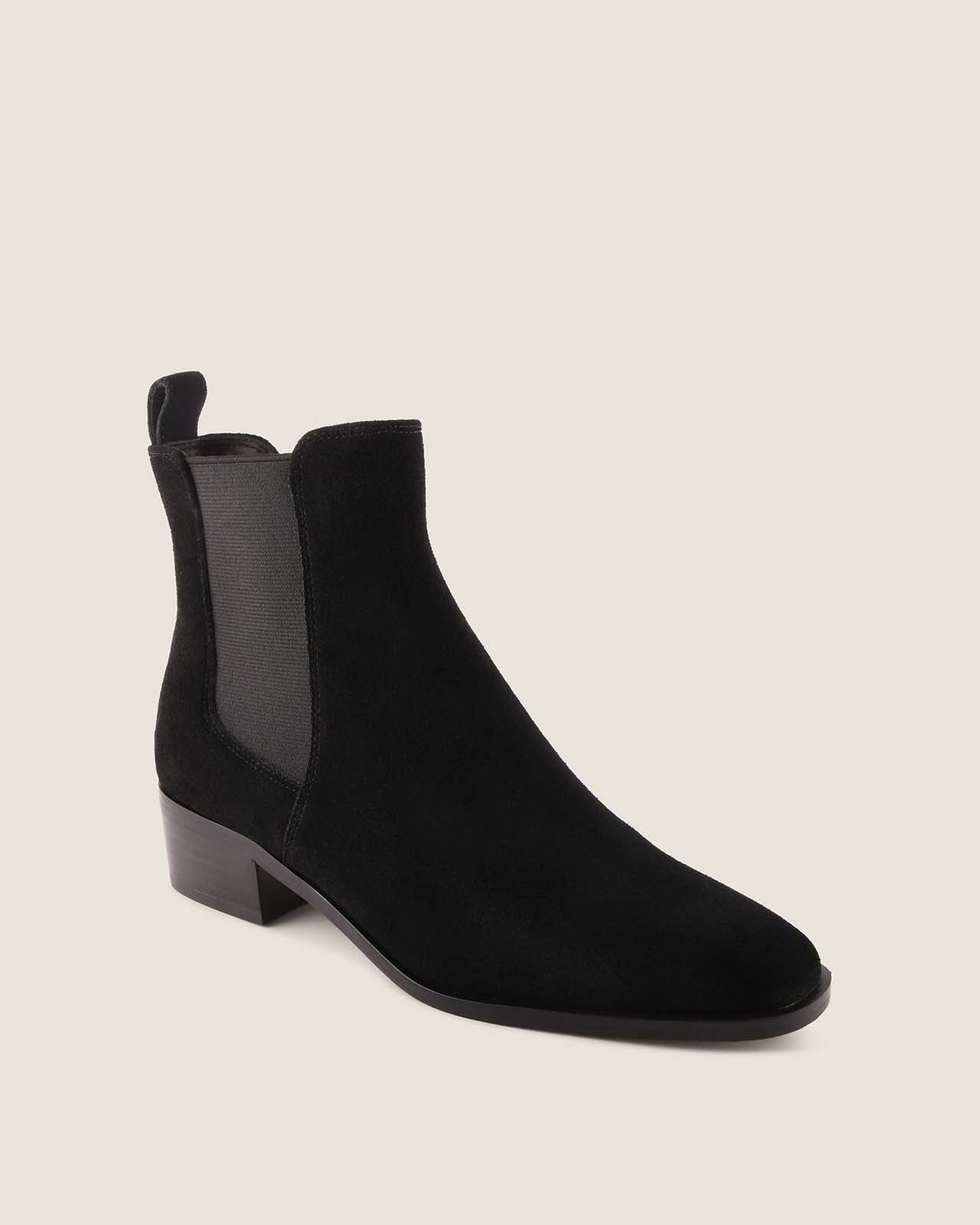 Black suede boot on a light grey background