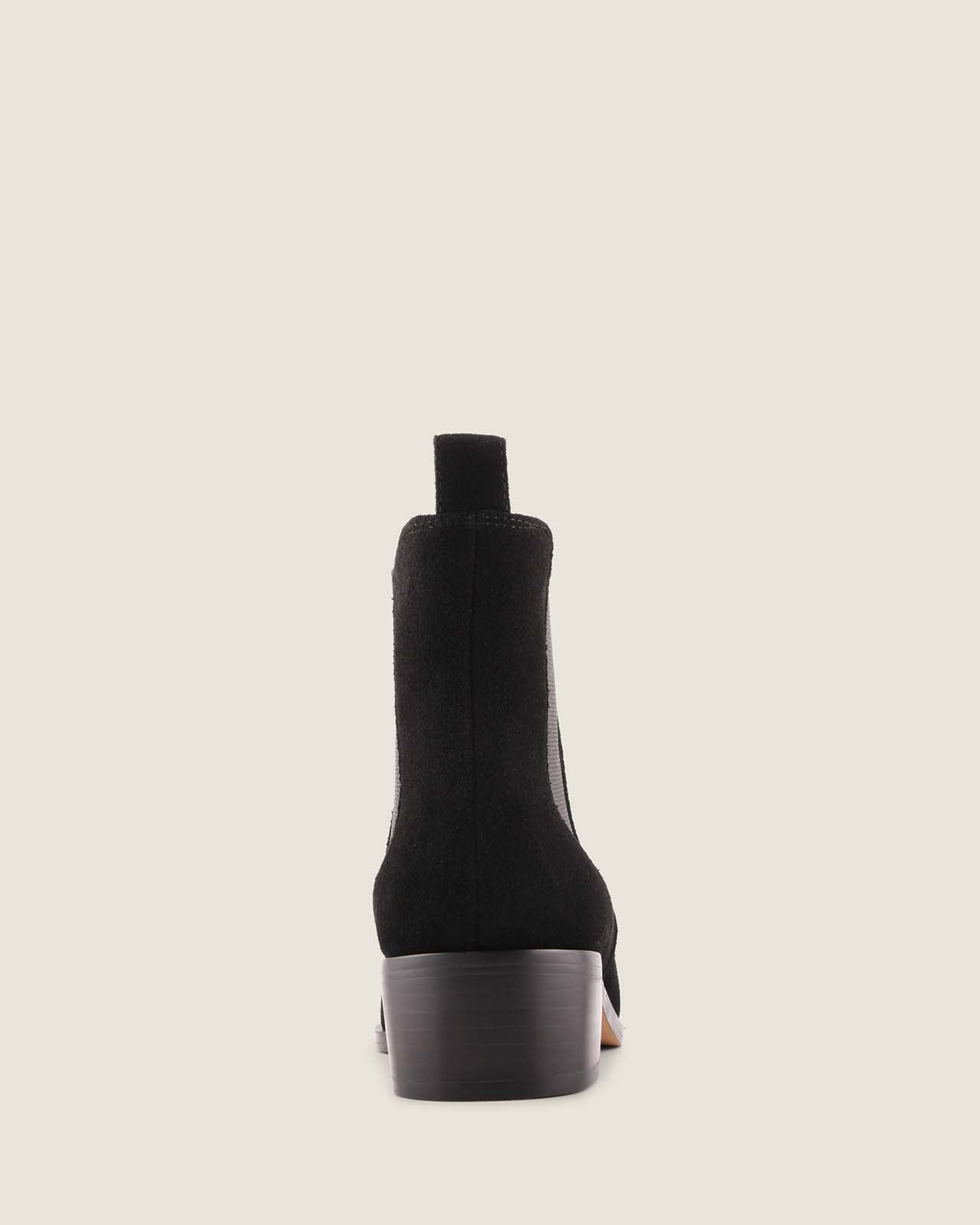 Black suede boot on a light grey background