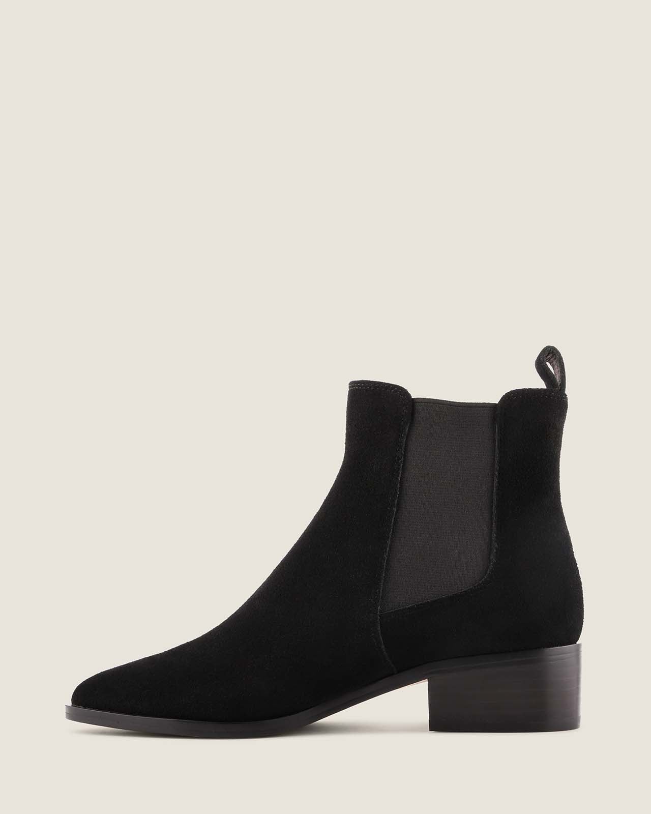 Black suede boot on a light grey background