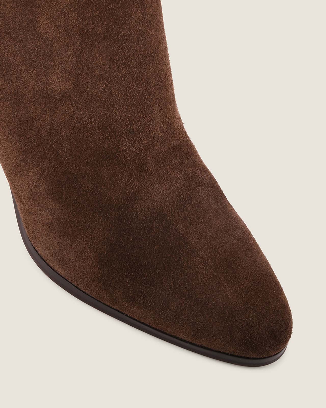 Brown suede boot on a light grey background