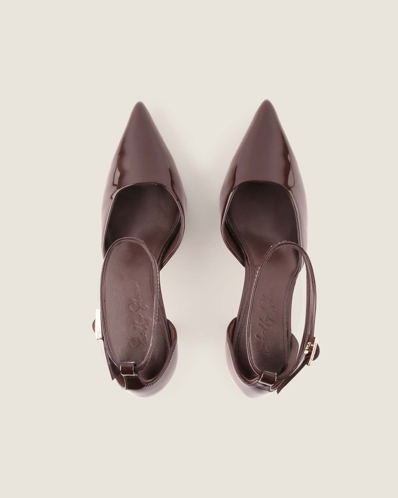 Pair of brown high-heeled shoes on a light gray background