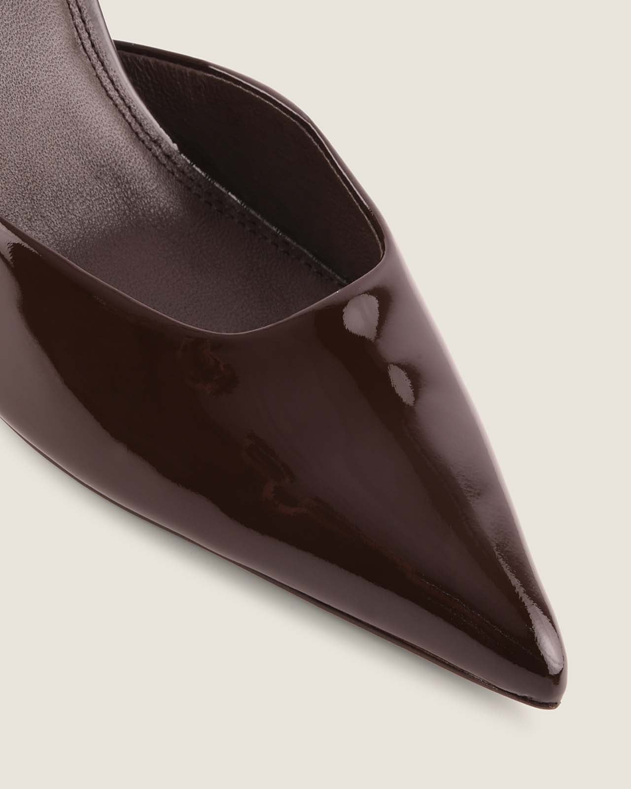 Shiny black pointed-toe shoe on a light gray background