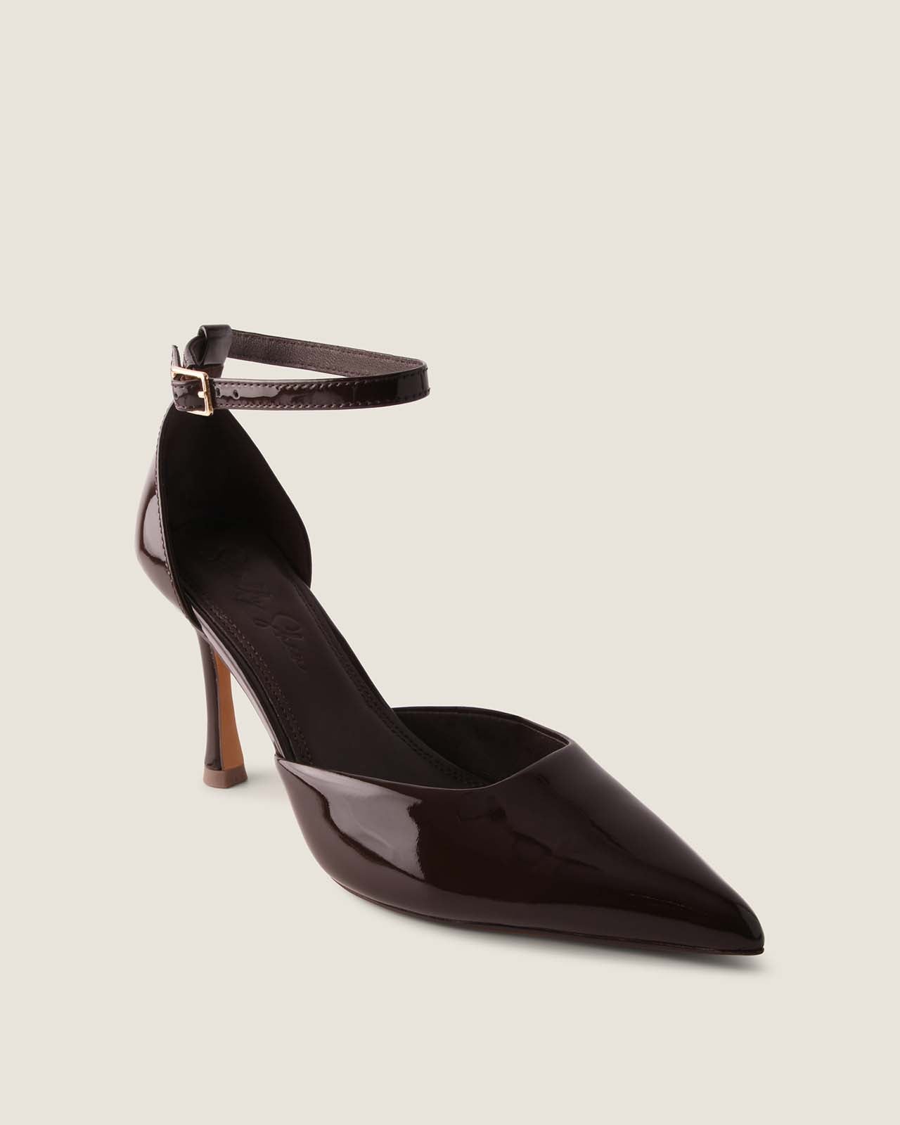 Black patent leather high-heeled shoe with a thin strap on a light gray background