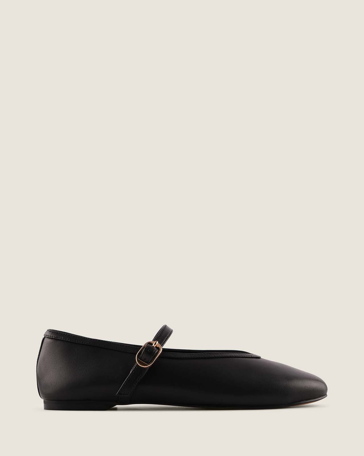 Black sneaker with gold accents on a white background