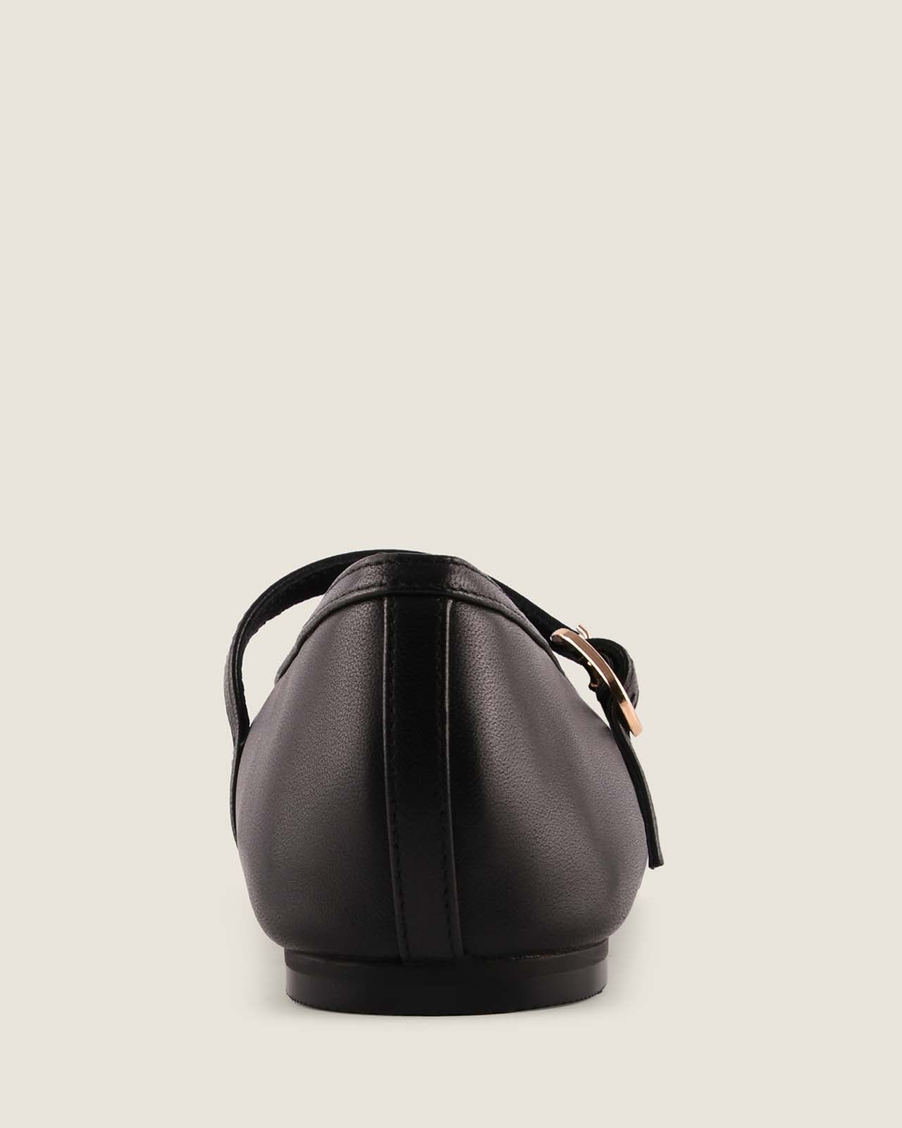 Black leather sandal on a light beige background