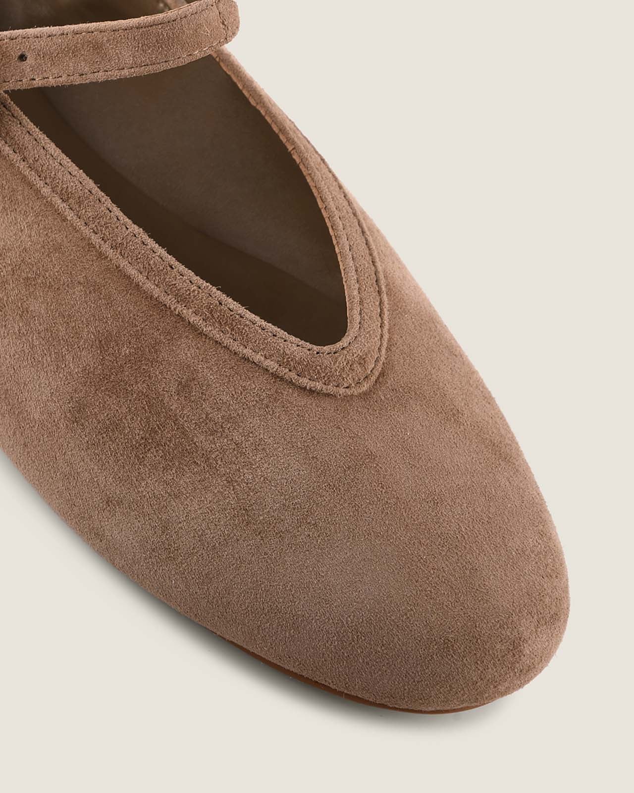 Brown suede ballet flat shoe on a light background