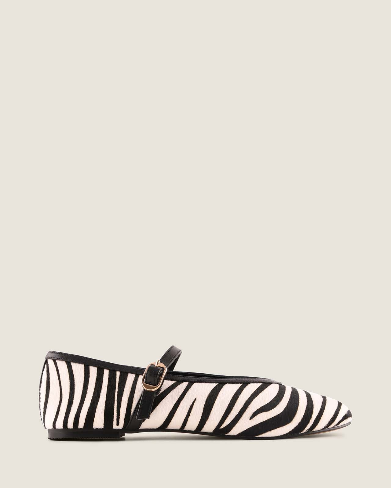 Zebra-striped flat shoe on a light gray background