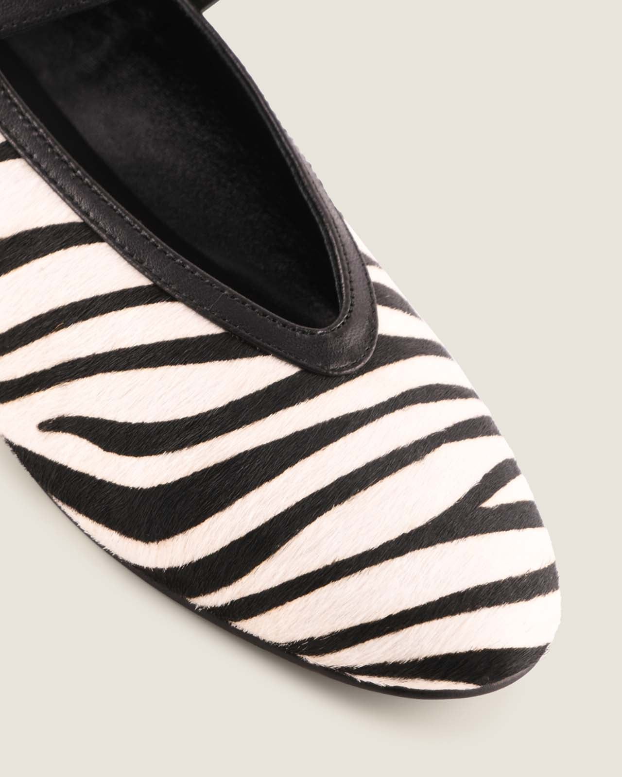 Black and white zebra-striped shoe on a light gray background