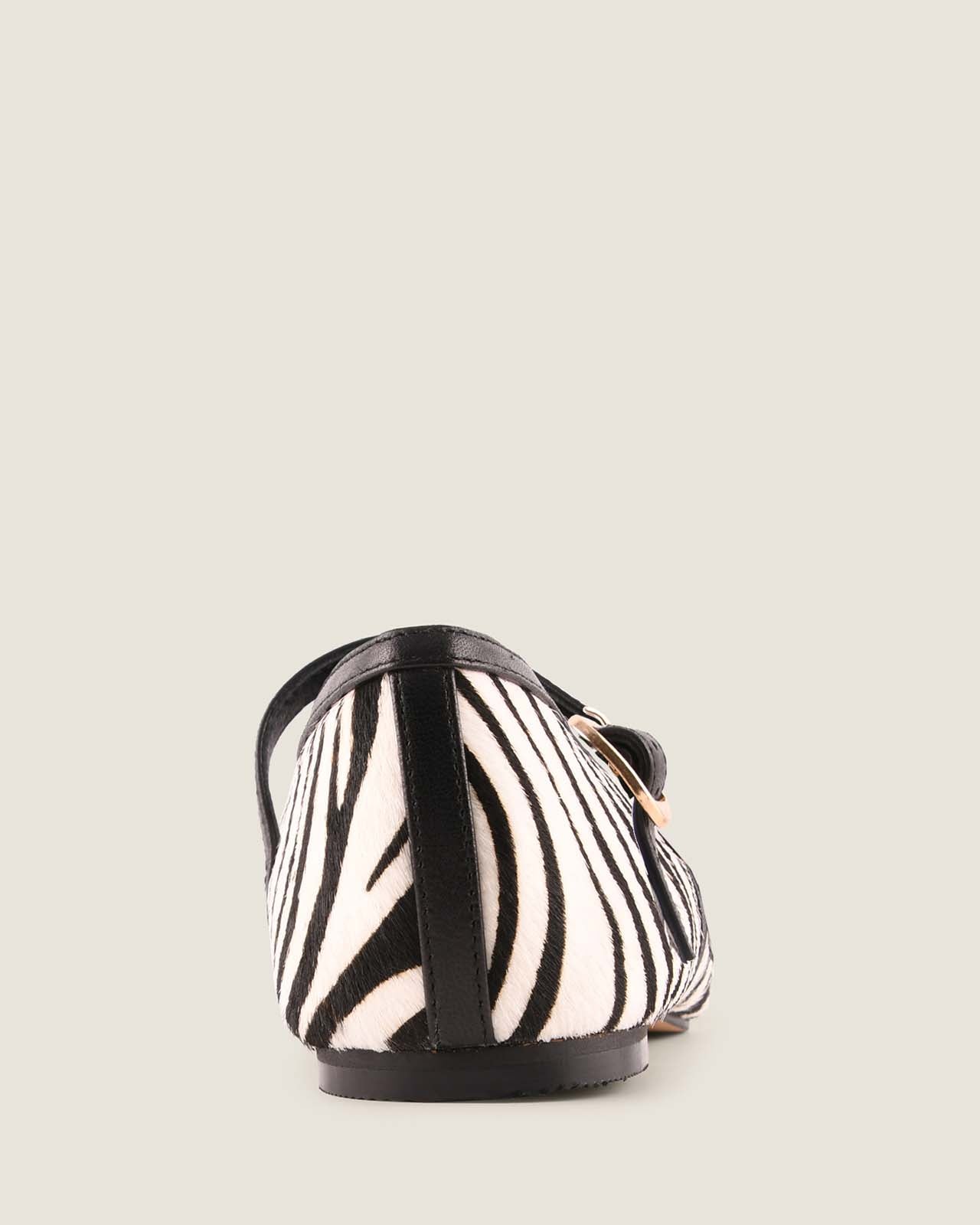 Zebra-patterned flat shoe on a light beige background