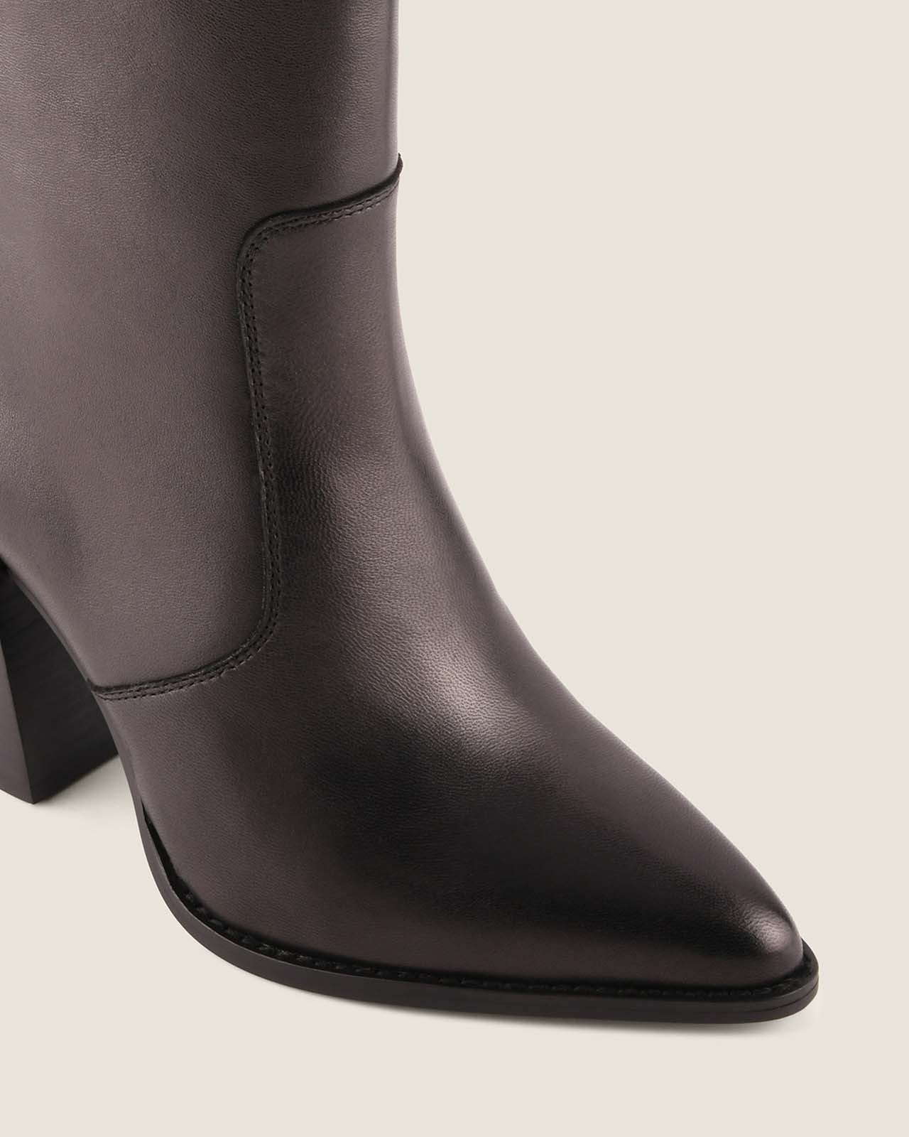 Dark brown knee-high boot with a pointed toe on a light gray background