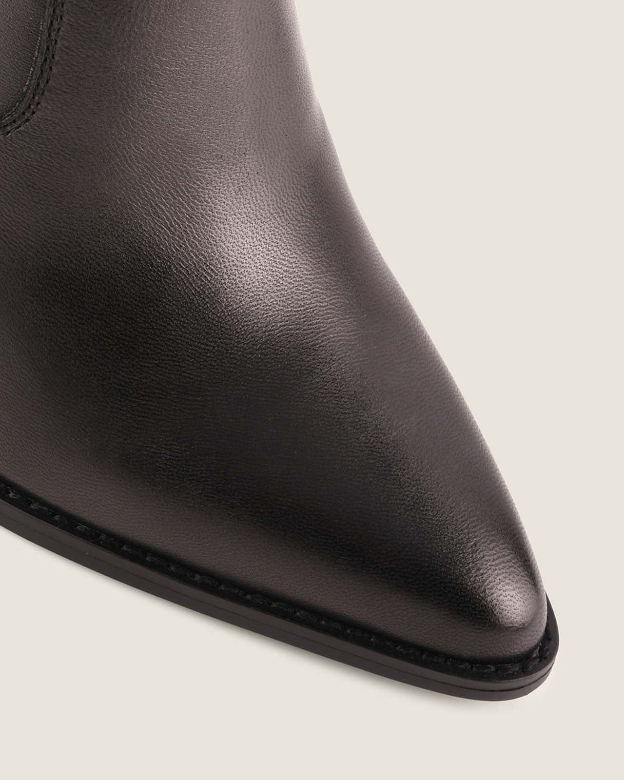 Black leather ankle boot on a light gray background