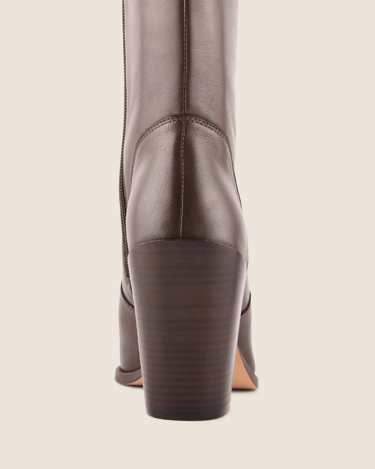 Brown leather boot on a light beige background