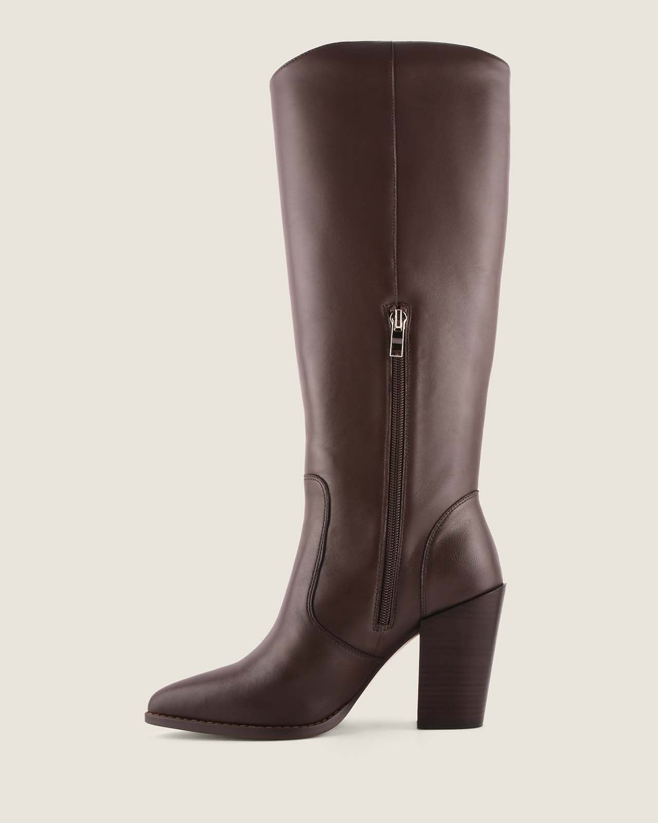 Brown knee-high boot with a zipper on a beige background