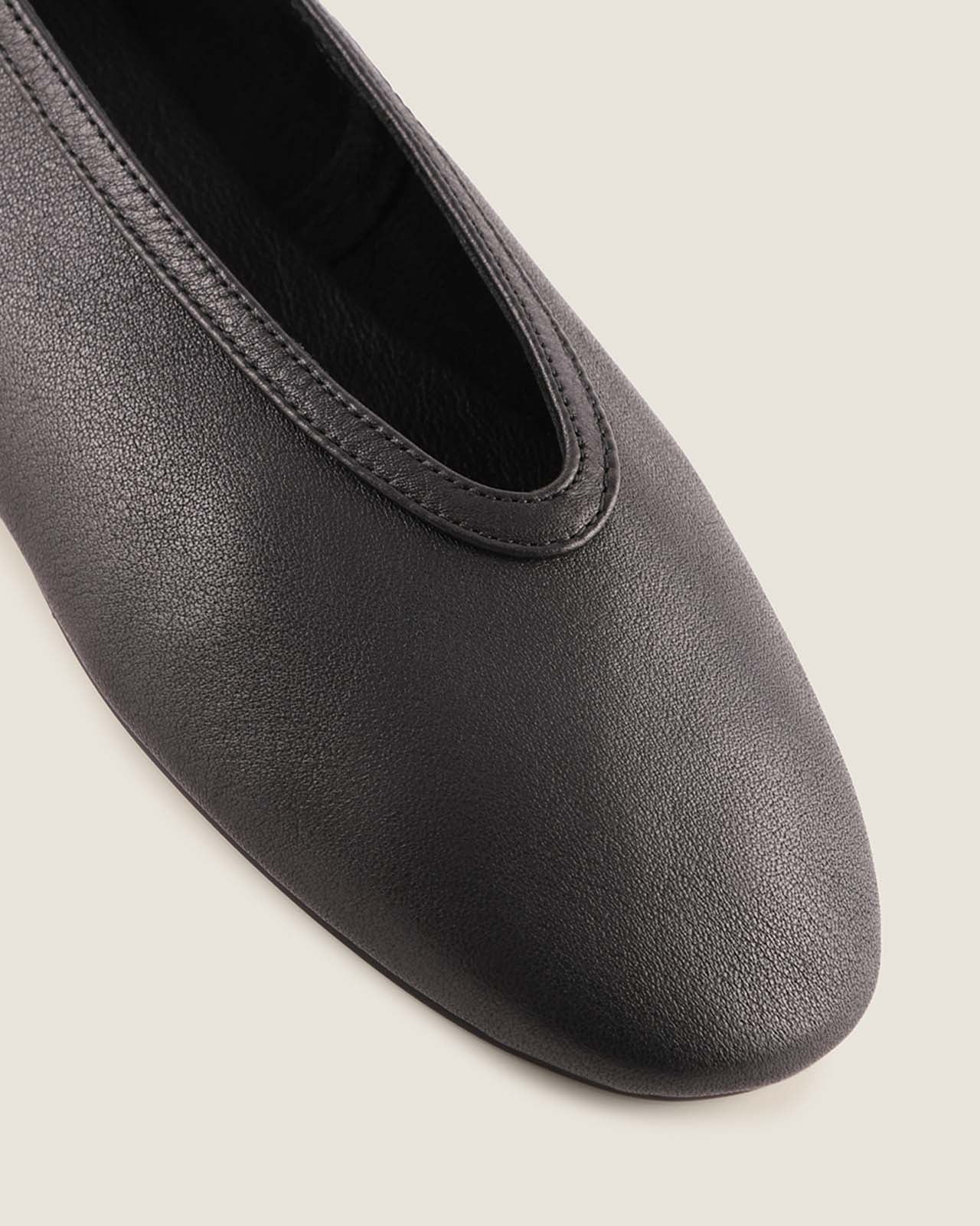 Black ballerina shoe on a light gray background