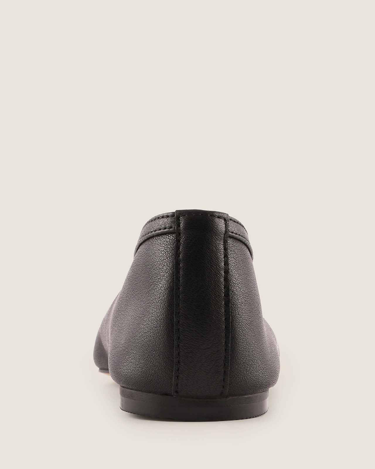 Black leather shoe on a light gray background