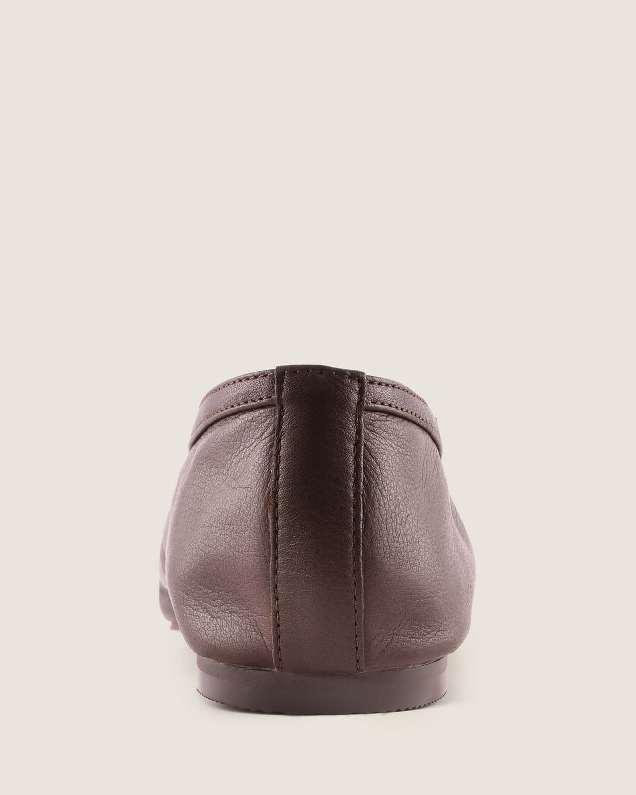 Brown leather shoe on a light beige background
