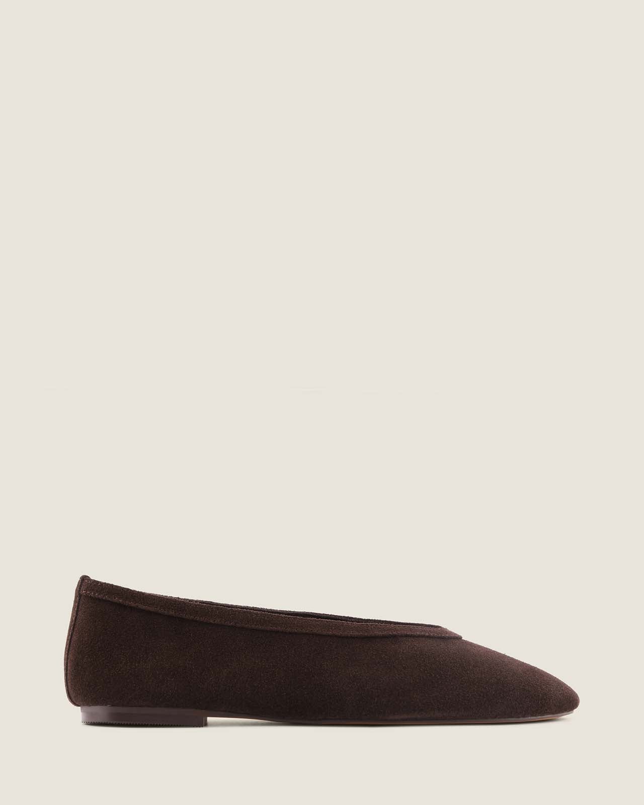 Brown flat shoe on a light beige background