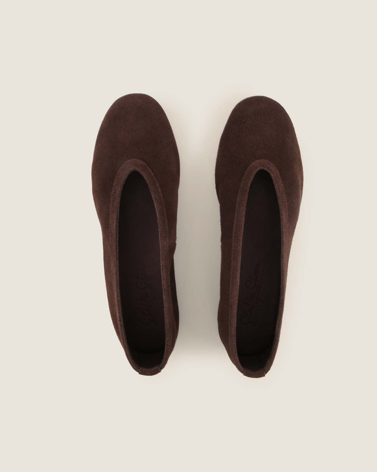 Pair of brown slippers on a light beige background